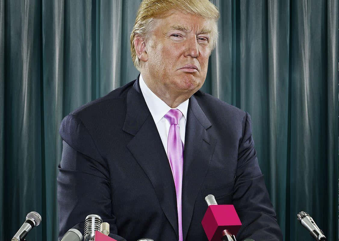 trump 桌布 壁紙 — 一名身穿深色西裝、繫著粉紅色領帶的男子，站在設有咪高峰的講台上，背景是綠色窗簾。