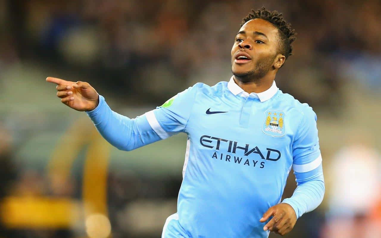 Sterling 桌布 壁紙 — 一名身穿淺藍色曼城球衣的足球員，以強烈的表情向上指慶祝。