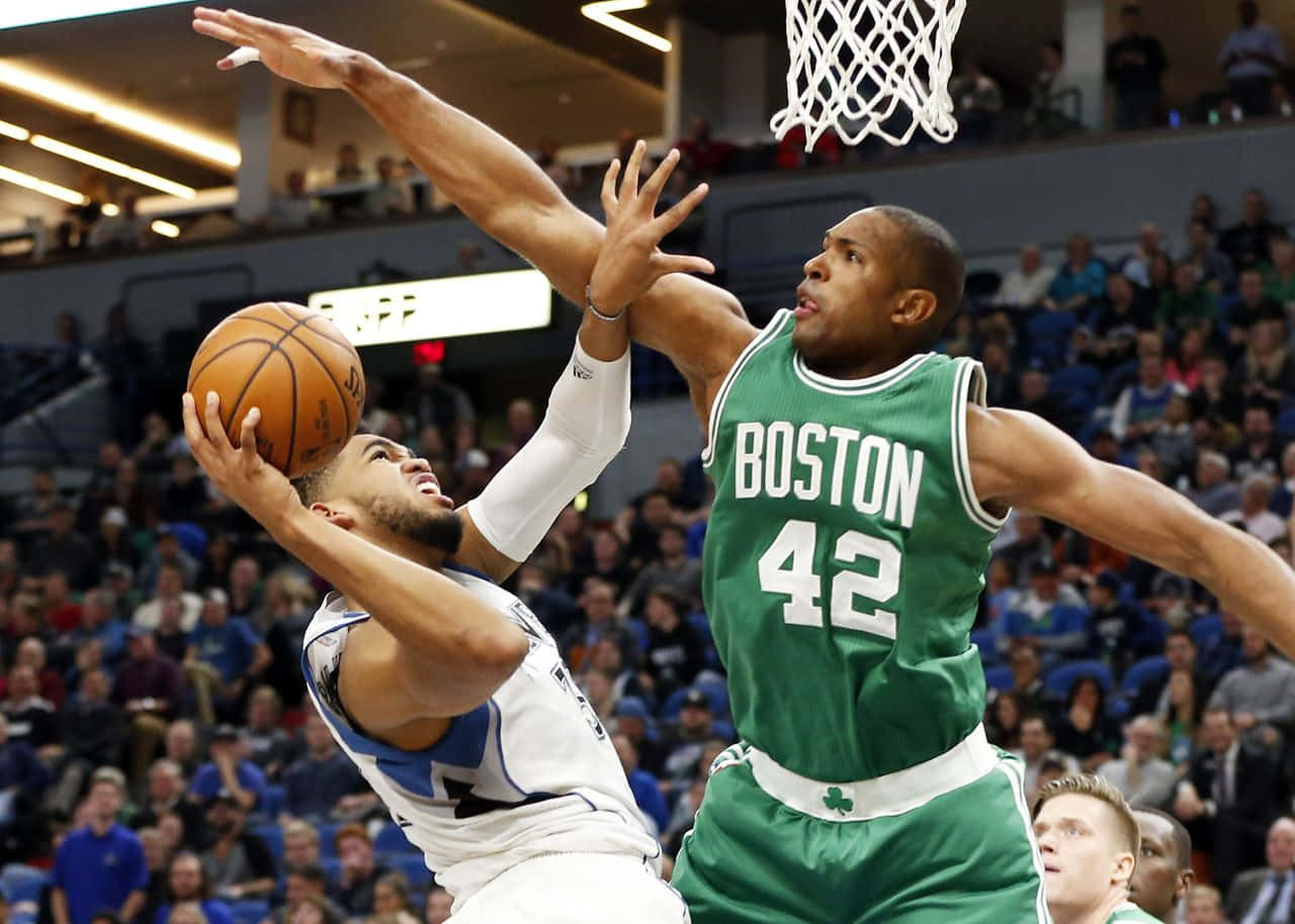 Al Horford 桌布 壁紙 — 一名身穿白色球衣的籃球運動員向籃框切入，同時被一名身穿綠色球衣的波士頓塞爾特人球員防守。