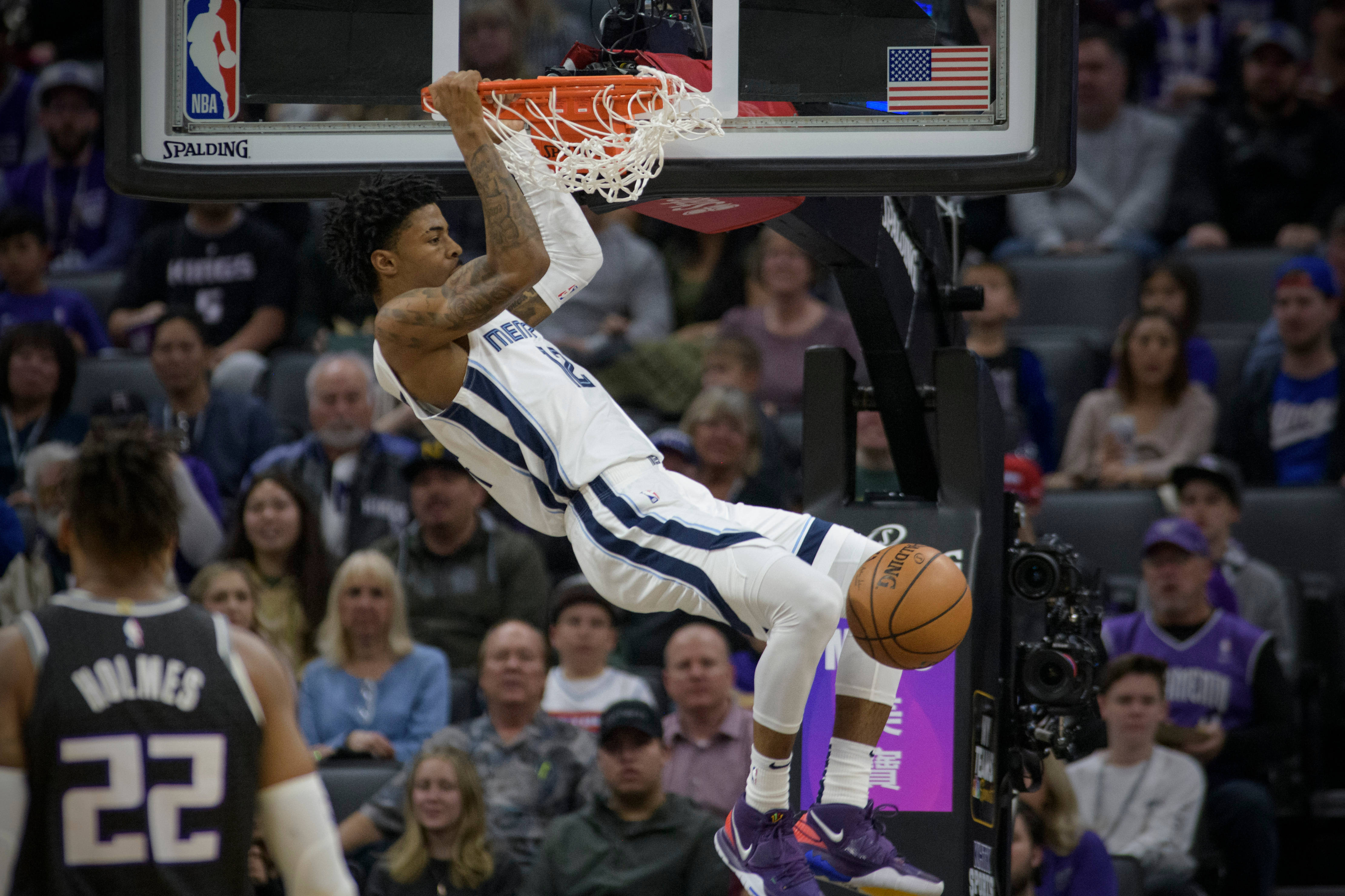 Ja Morant 入樽 桌布 壁紙 — 一名身穿白色球衣的籃球運動員在比賽中單手入樽，同時懸掛在籃框上。