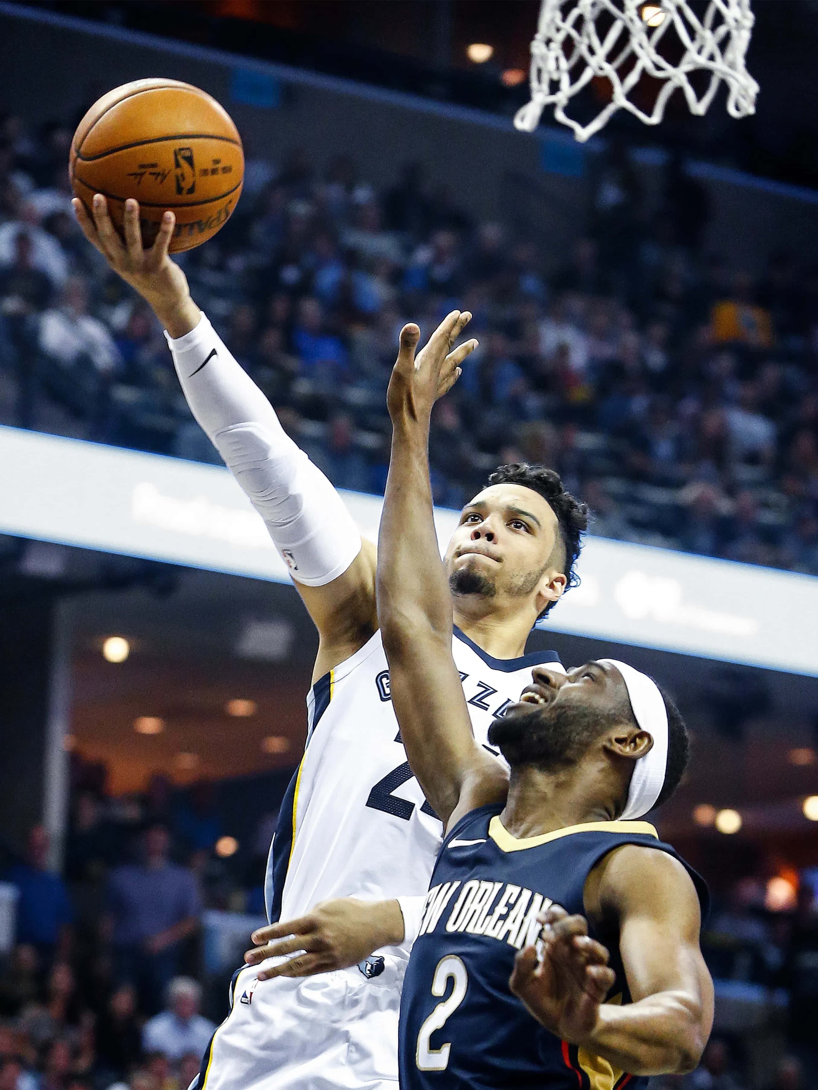 Dillon Brooks 桌布 壁紙 — 一名身穿白色球衣的籃球運動員跳向籃框，而一名身穿海軍藍的防守球員試圖封阻他的投籃。