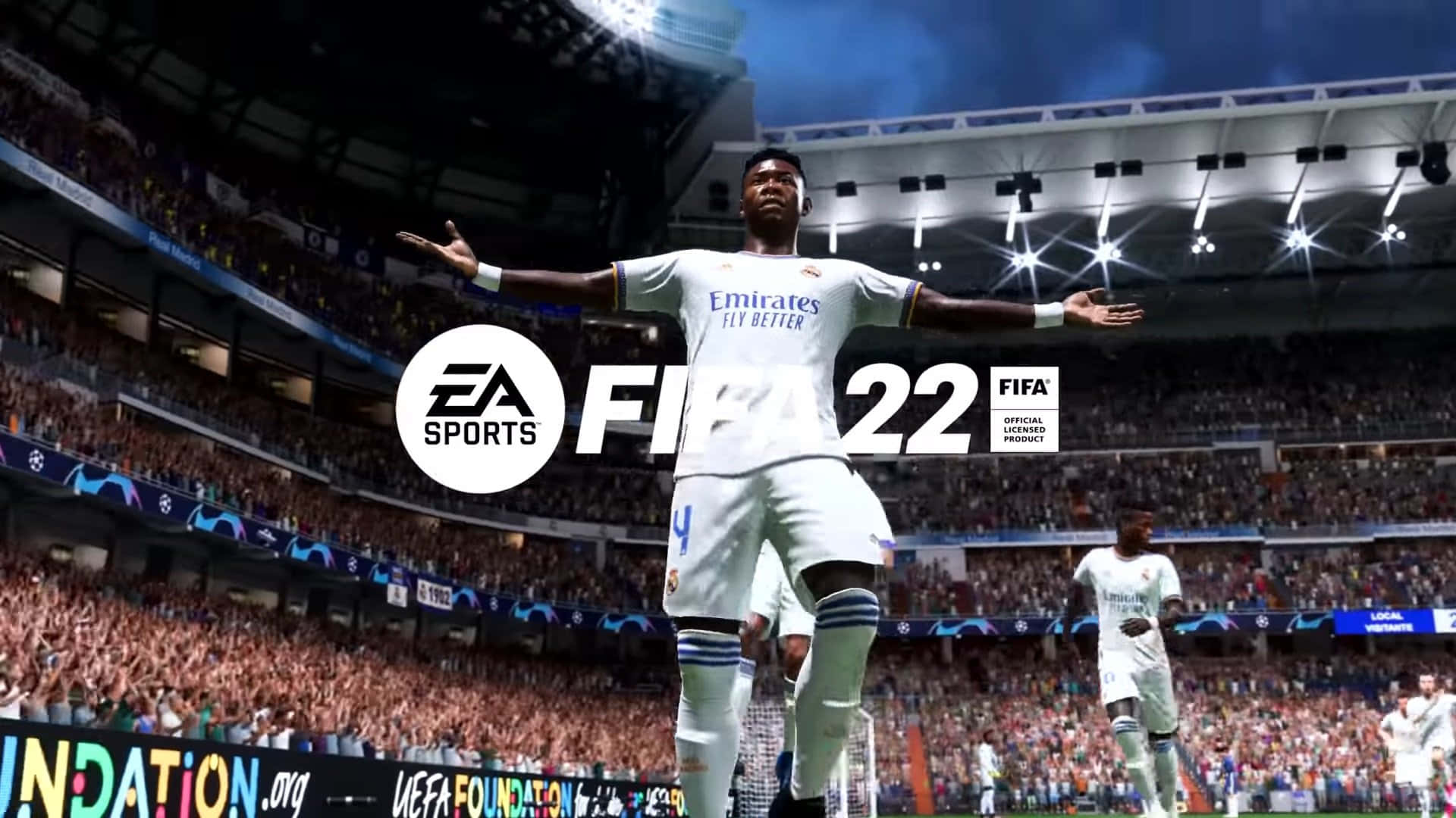 Fifa 22 桌布 壁紙 — 一名身穿白色皇家馬德里球衣的足球運動員在球場燈光下張開雙臂慶祝，周圍是歡呼的人群。