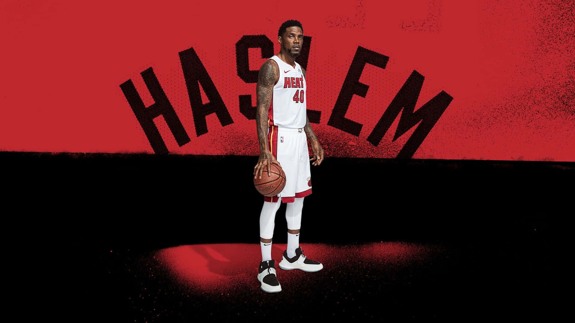 Udonis Haslem 桌布 壁紙 — 一名身穿白色邁阿密熱火球衣的籃球運動員，在帶有粗體黑色大字「HASLEM」的紅色背景前持球站立。
