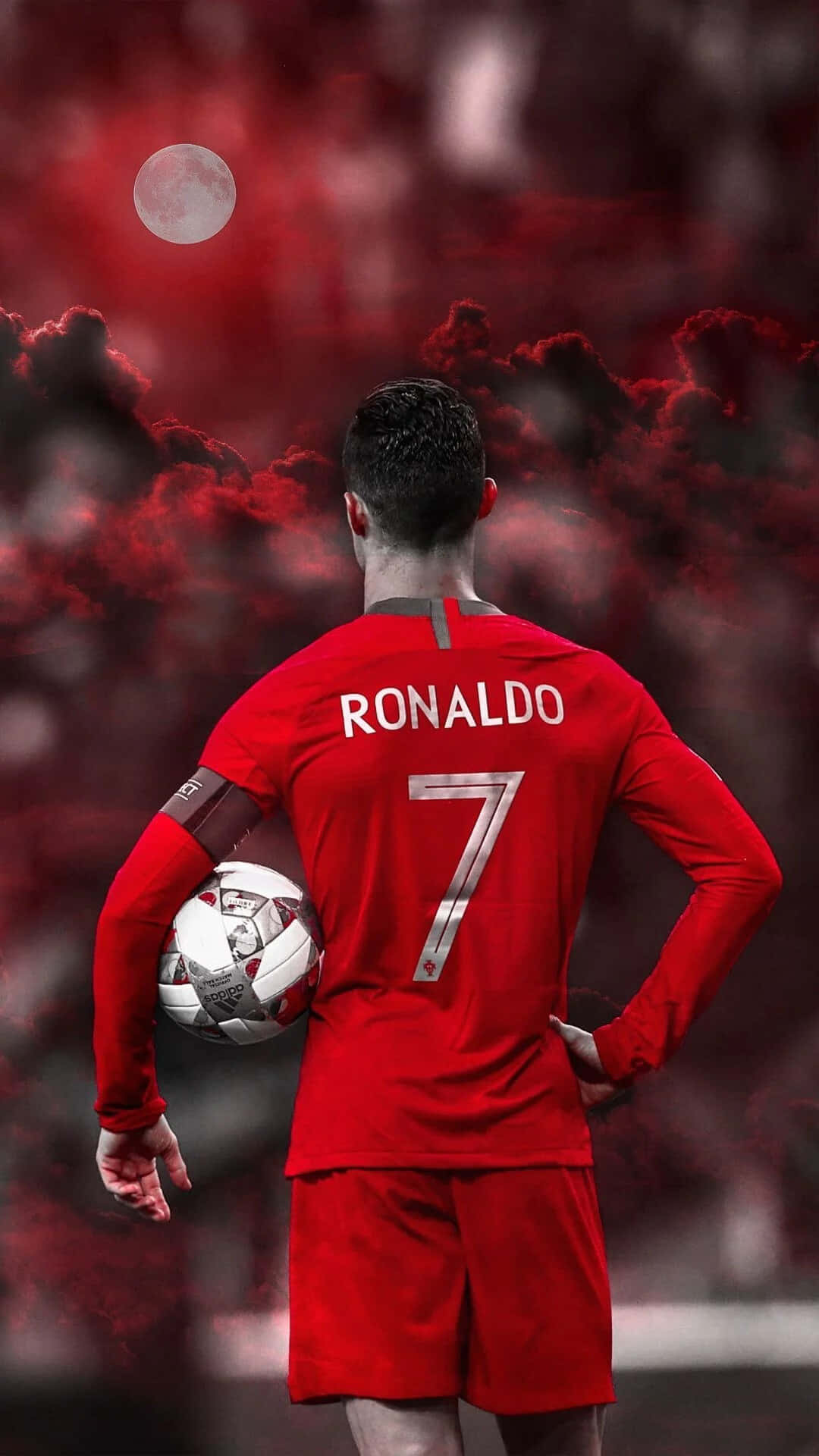 Cristiano Ronaldo 桌布 壁紙 — 一名身穿紅色7號球衣的足球員在滿月下，以戲劇性的紅色天空為背景，手持足球站立。