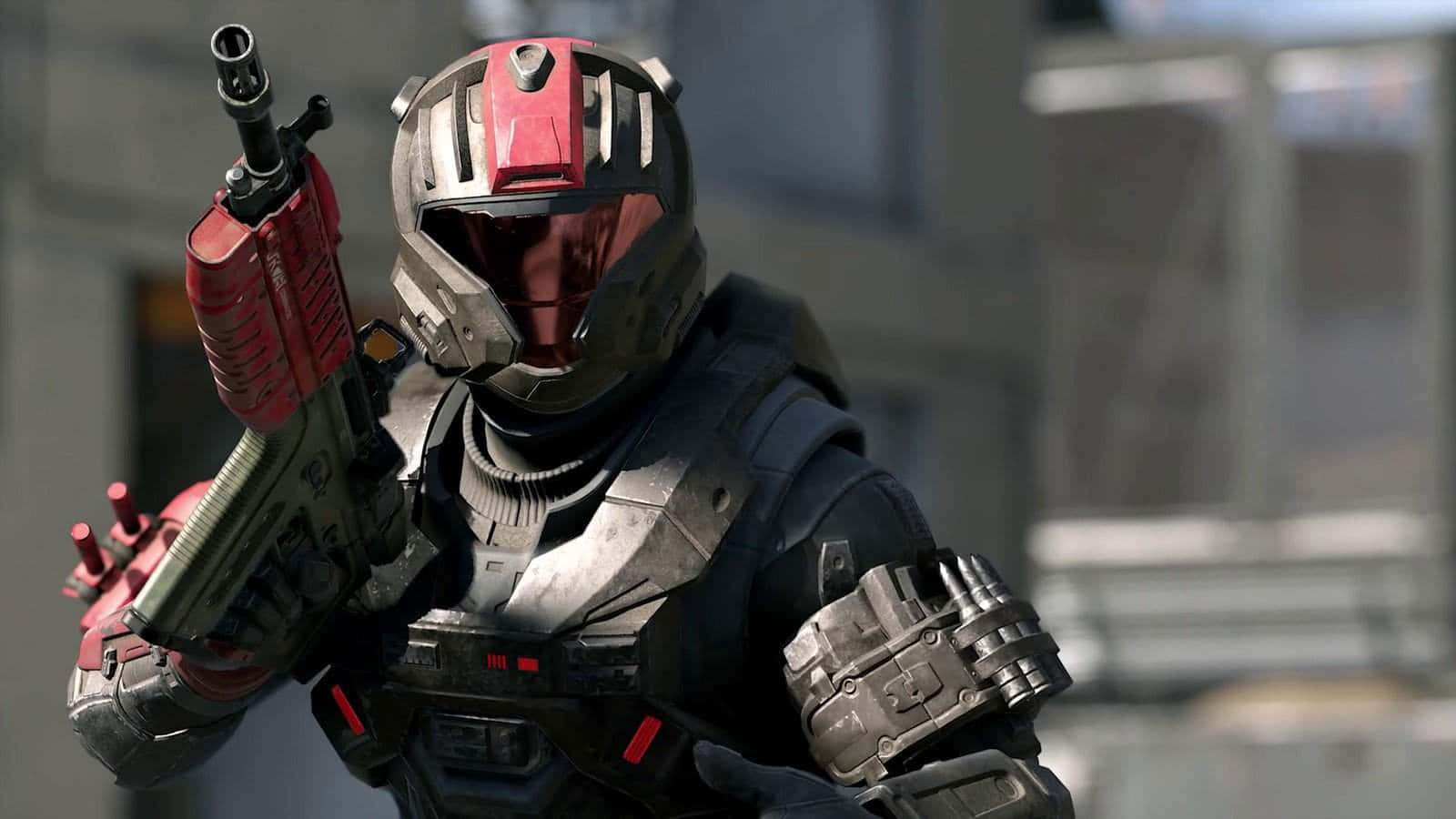 Halo Infinite 桌布 壁紙 — 一名身穿紅色和灰色裝甲裝備的士兵在堅韌的城市環境中手持未來武器。