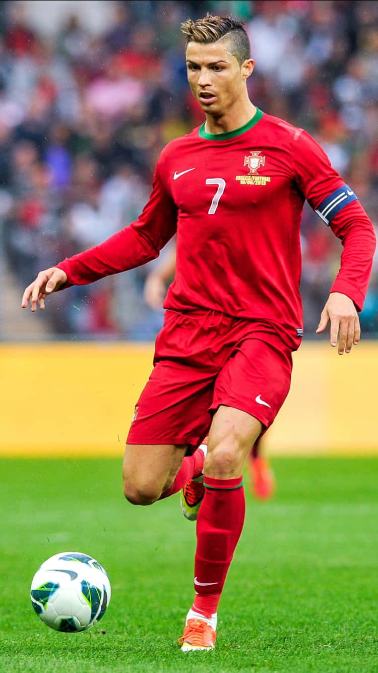 Ronaldo 桌布 壁紙 — 一名身穿紅色葡萄牙球衣的足球運動員在明亮的球場燈光下，在充滿活力的綠色球場上運球。