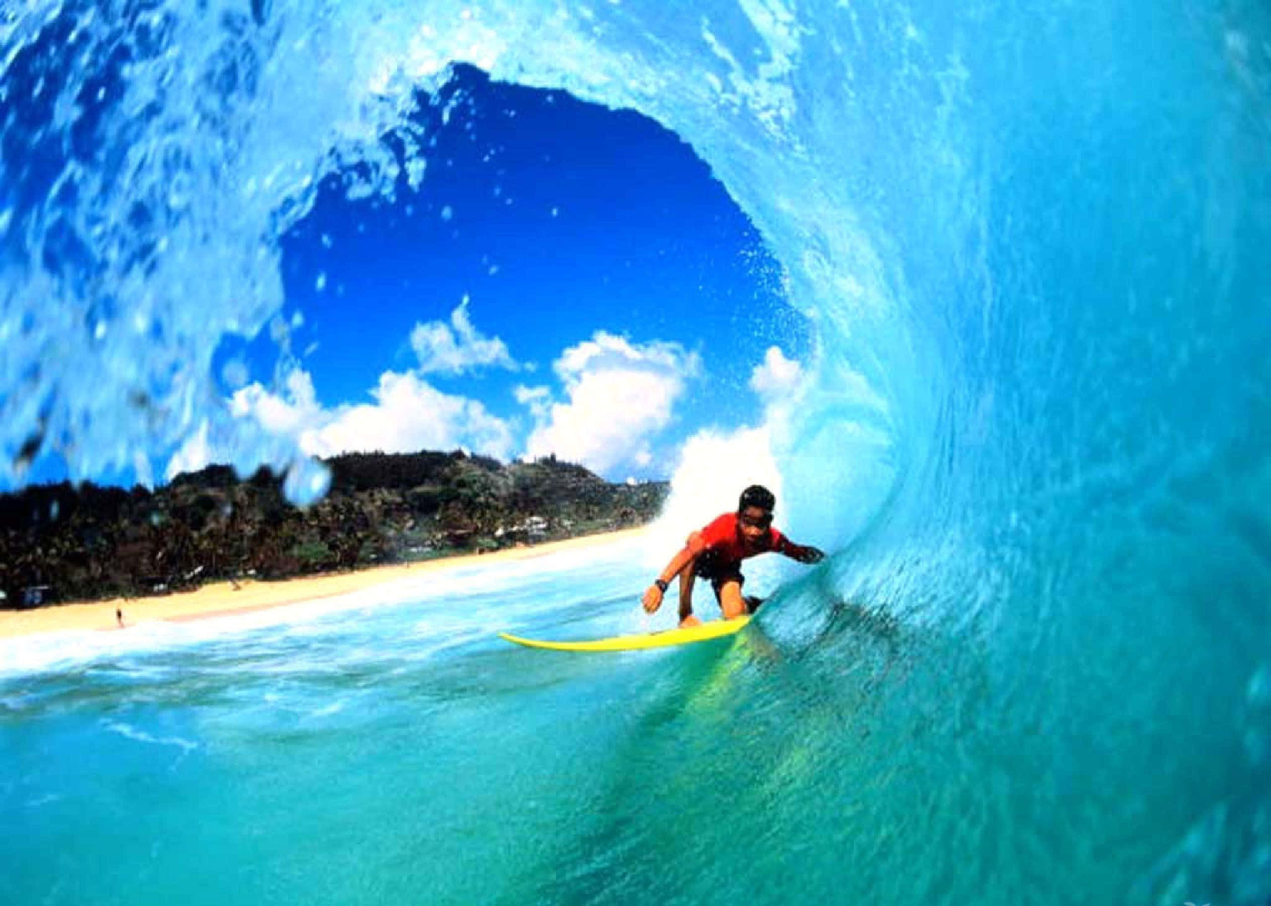 surfing 桌布 壁紙 — 一名身穿紅色襯衫的衝浪者騎著藍綠色海浪穿過完美的管浪，透過管浪可以看到沙灘和綠色山丘。