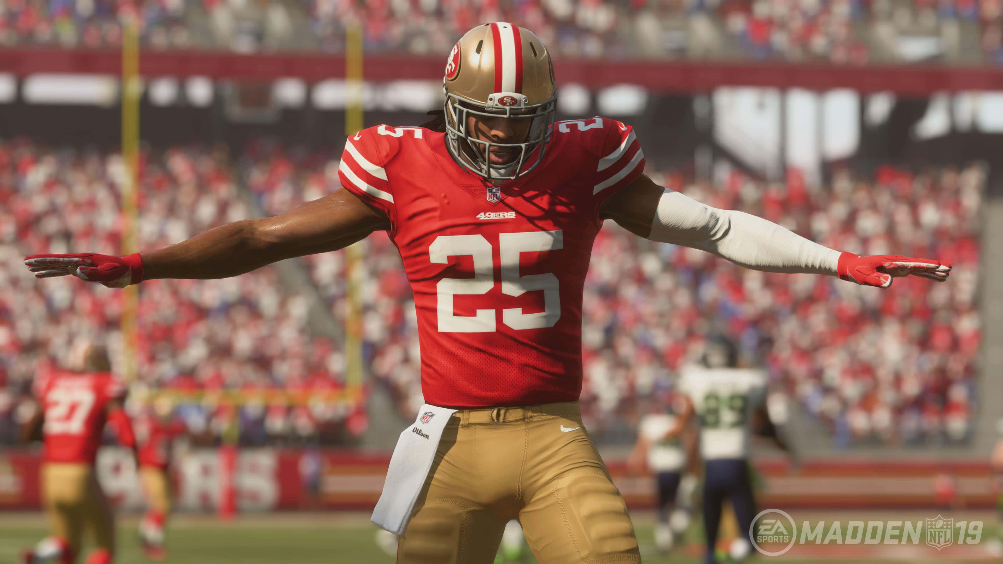 Madden NFL 22 桌布 壁紙 — 一名身穿紅金色球衣的足球運動員在陽光明媚的球場上張開雙臂慶祝。