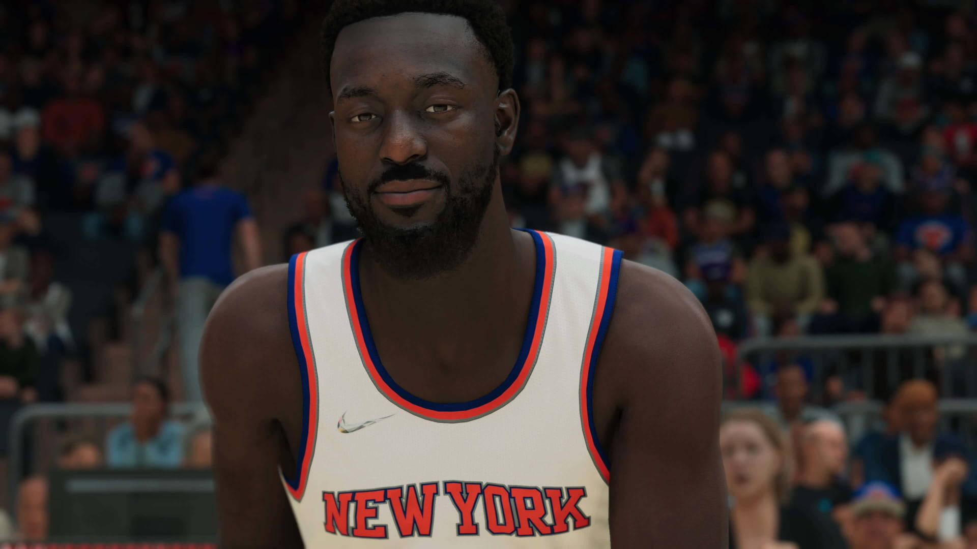 Kemba Walker NBA 2K22 壁紙 — 一名身穿紐約人隊球衣的籃球運動員在擠滿觀眾的場館內專注地凝視著鏡頭。