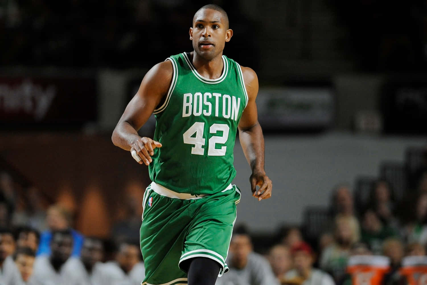 Al Horford 桌布 壁紙 — 一名身穿綠色波士頓塞爾特人球衣、號碼42的籃球運動員在場館燈光下於比賽中動態奔跑。