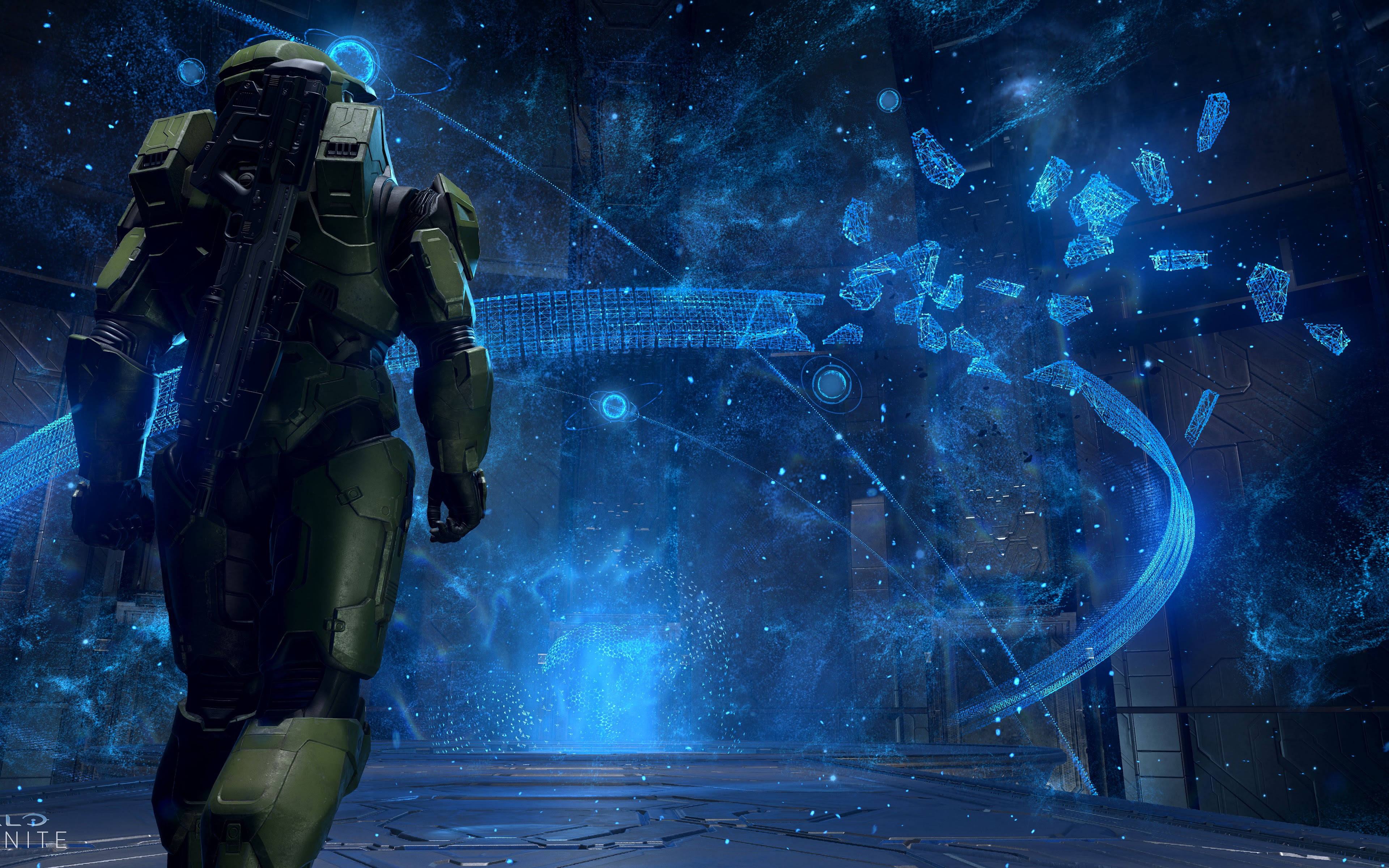 Halo Infinite 4K 桌布 壁紙 — 一名身穿綠色盔甲的士兵站在未來科幻場景中發光的藍色全息界面前。