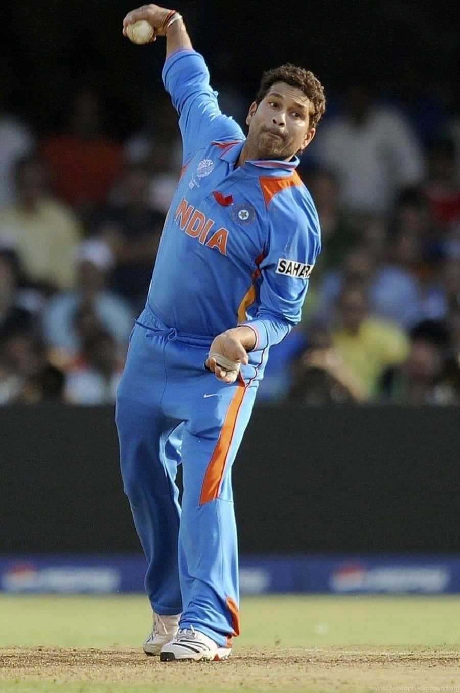 Sachin Tendulkar 桌布 壁紙 — 一名身穿藍色印度隊服的板球投手在明亮的燈光下於球場上投球。