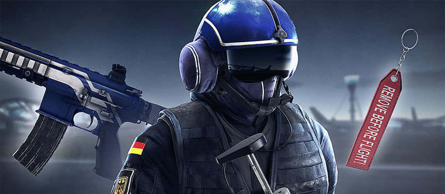 Rainbow Six Siege Jager 桌布 壁紙 — 一名身穿藍色戰術裝備的士兵手持步槍，附近掛著一個「REMOVE BEFORE FLIGHT」標籤。