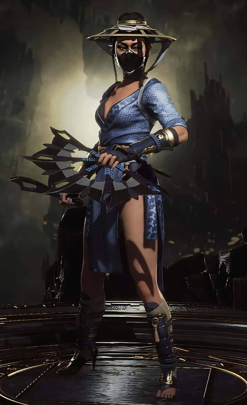 Mortal Kombat Kitana 桌布 壁紙 — 一名身穿藍色盔甲、戴著寬邊帽的蒙面戰士，在黑暗煙霧繚繞的背景中，手持扇子武器蓄勢待發。