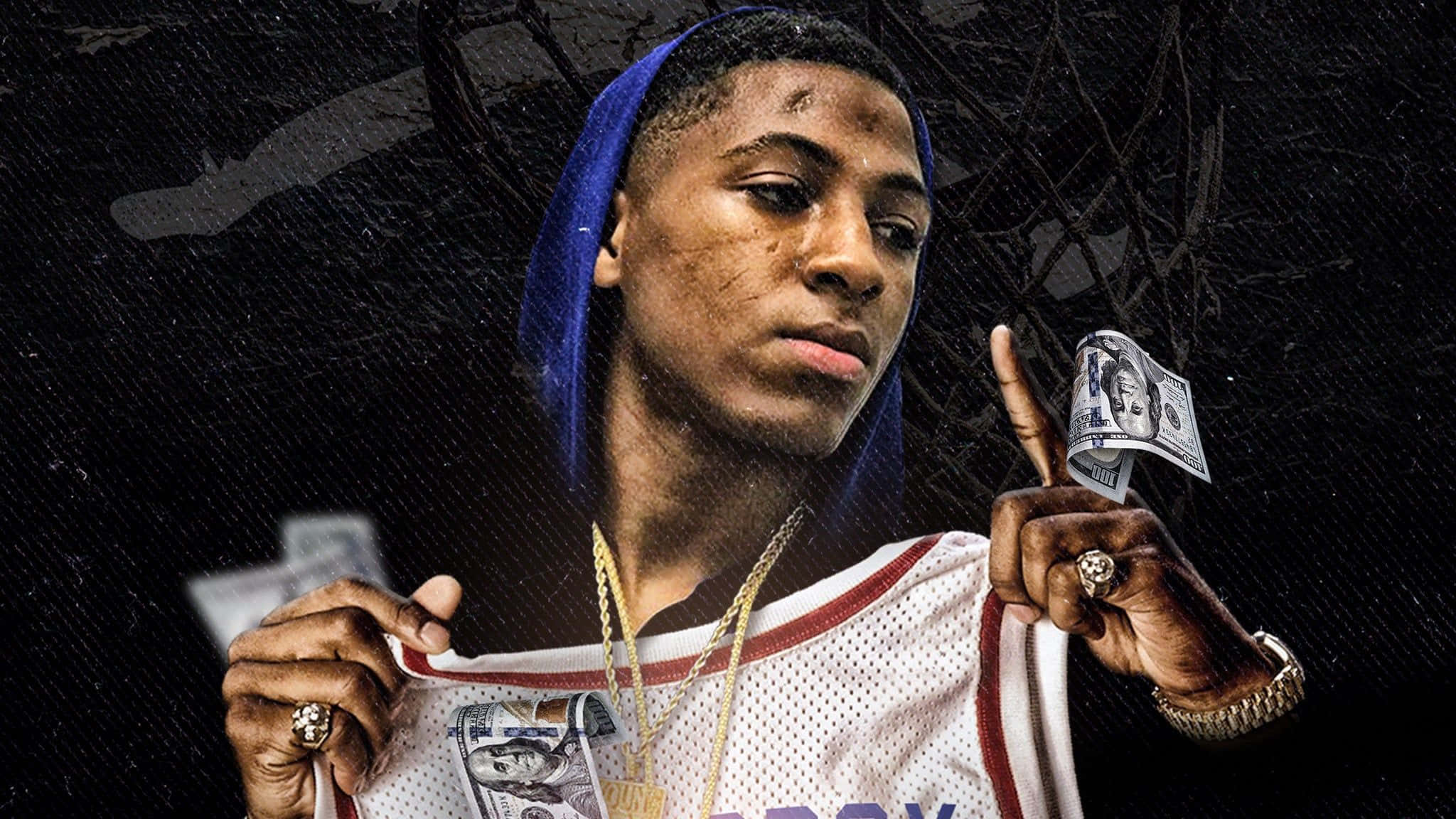 Never Broke Again Kentrell DeSean Gaulden 壁紙 — 一名身穿藍色連帽衫和籃球球衣的年輕男子，在深色紋理背景前，手持金錢和美元鈔票，專注地凝視鏡頭。