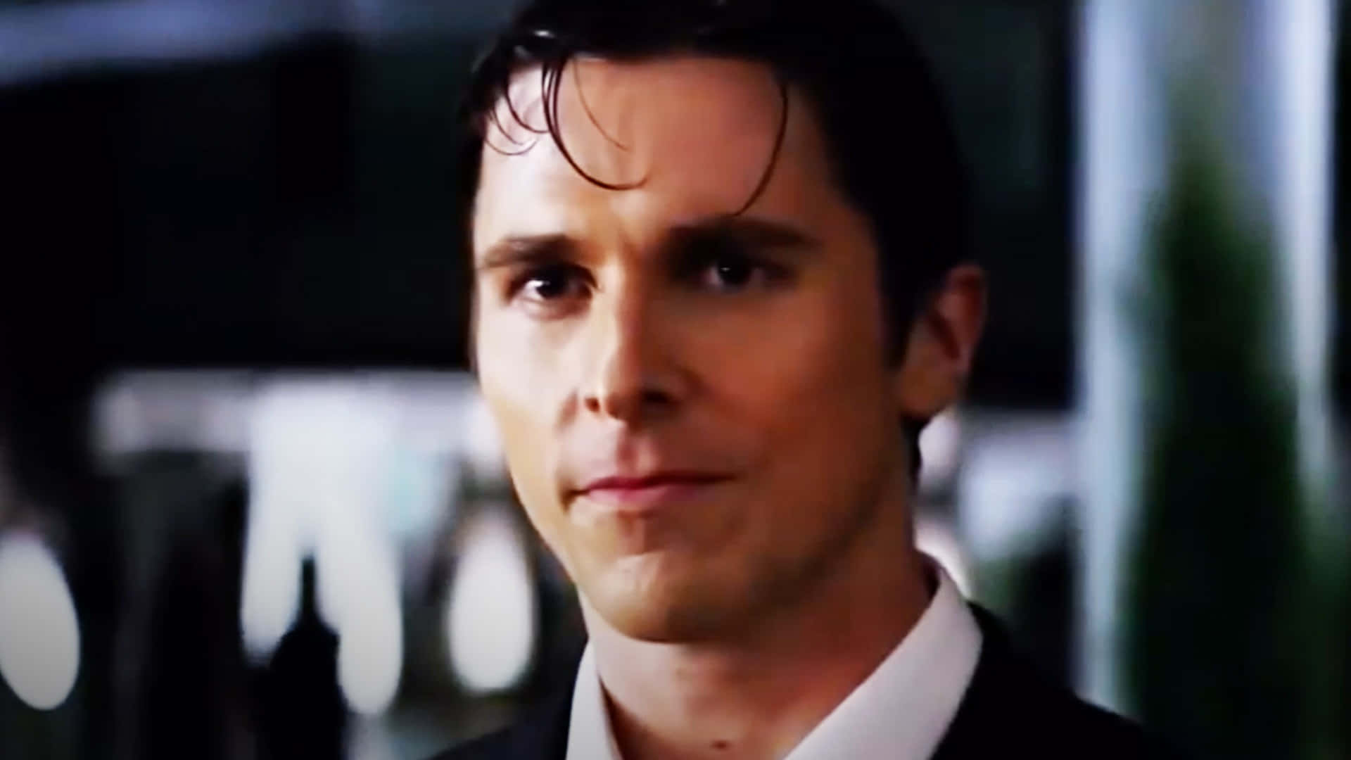 Batman Begins 桌布 壁紙 — 一名身穿西裝、頭髮濕透的男子在昏暗燈光下專注地向前看的特寫。