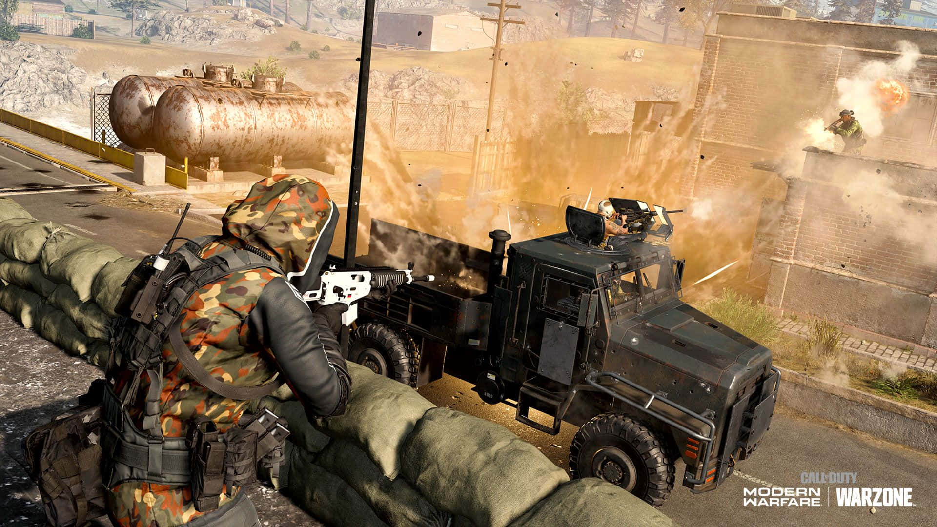 Call Of Duty Vehicles 桌布 壁紙 — 一名身穿迷彩服的士兵在沙包後方掩護，一輛裝甲卡車在塵土飛揚的城市戰場上爆炸。