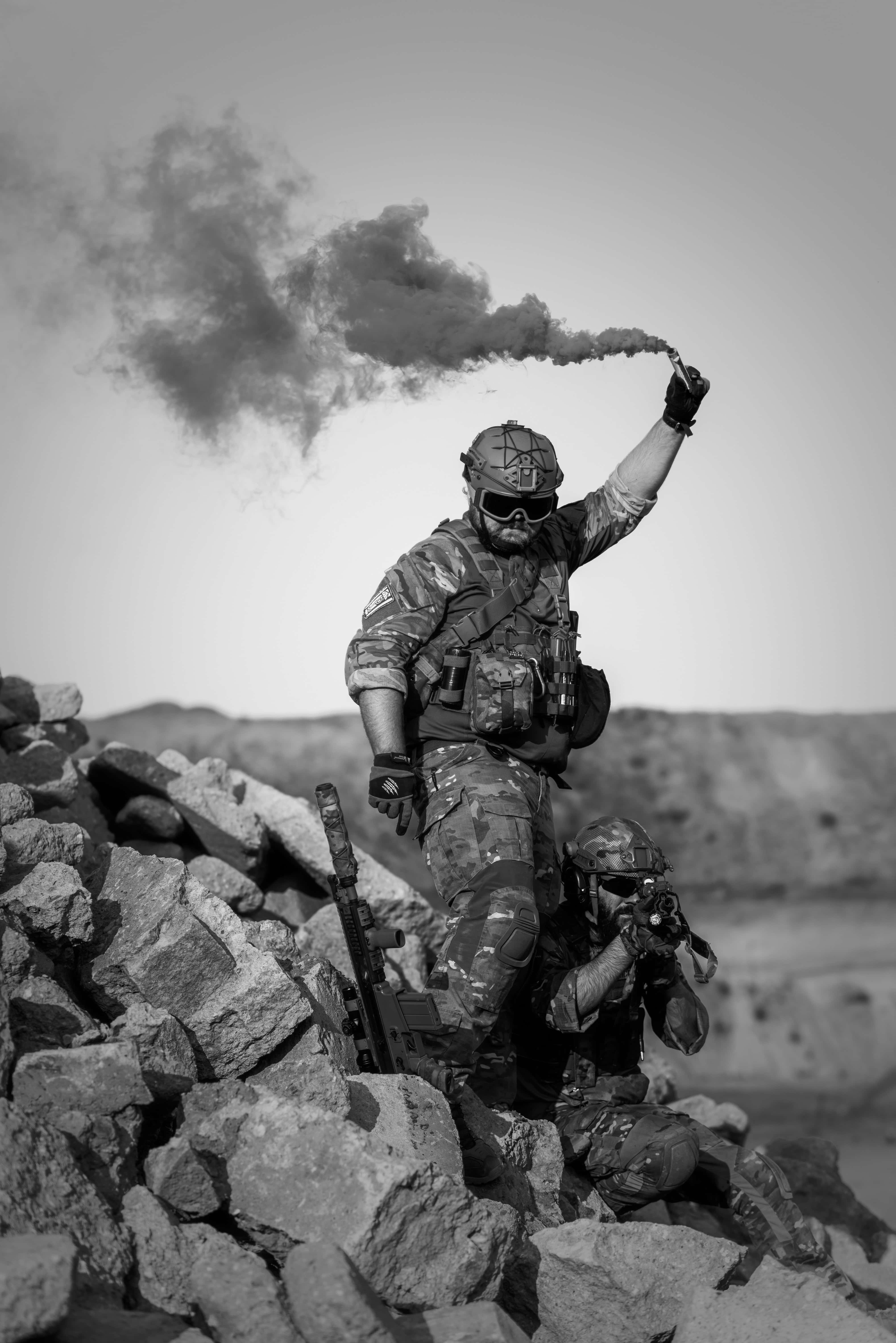 Dark War 桌布 壁紙 — 一名身穿迷彩裝備的士兵站在瓦礫上釋放煙霧信號彈，另一名士兵蹲在附近。
