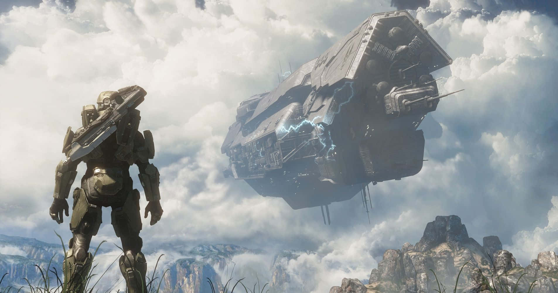 Halo Infinite 桌布 壁紙 — 一名身穿重型盔甲的士兵站在長滿青草的懸崖上，眺望著多雲天空下、山巒景觀上方懸浮的巨大未來太空船。
