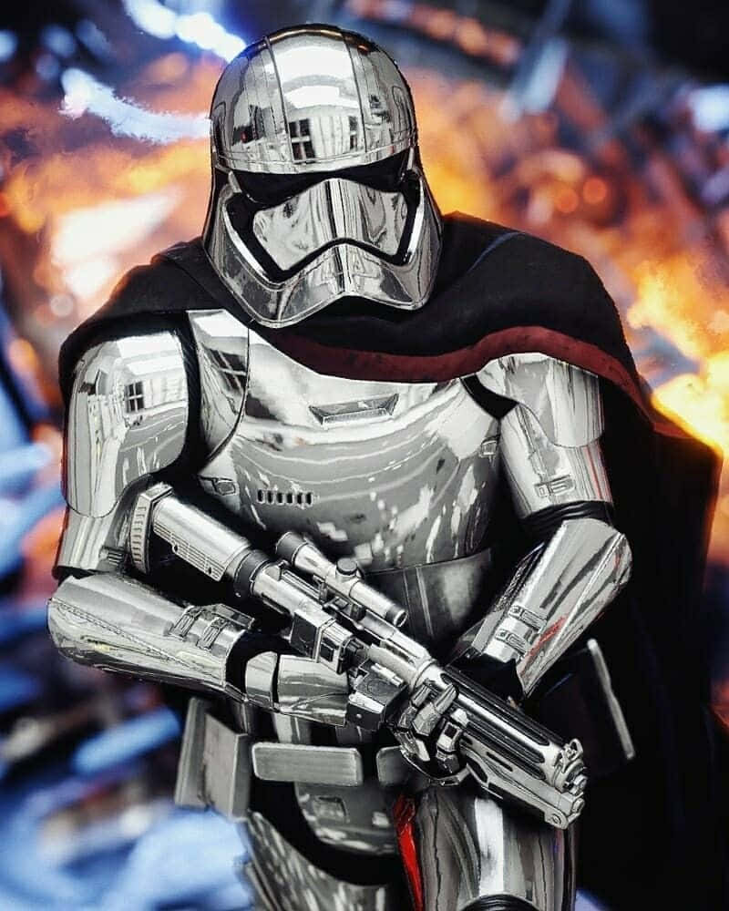Captain Phasma 桌布 壁紙 — 一名身穿鉻合金盔甲、披著黑色斗篷的風暴兵，在熾熱的戰鬥背景下手持爆能槍。
