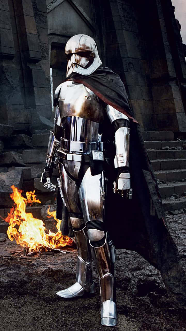 Captain Phasma 桌布 壁紙 — 一名身穿銀色盔甲的風暴兵站在古老的石頭廢墟前，腳邊熊熊燃燒的火焰投射出戲劇性的光芒。