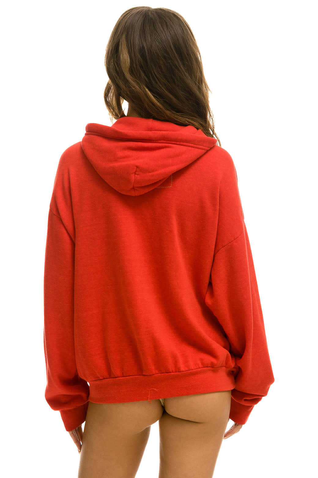 Red Hoodie 桌布 壁紙 — 一名身穿鮮紅色超大衛衣的女性背對相機，站在純白色背景前。