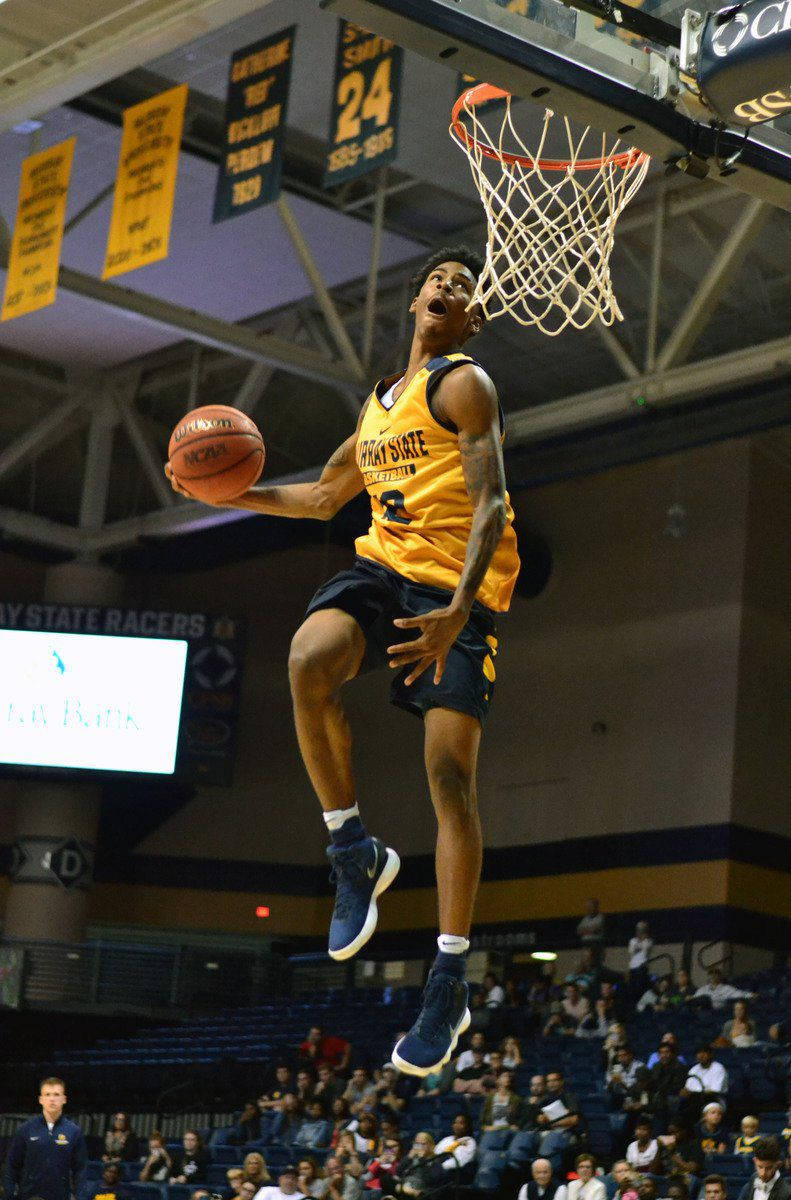 Ja Morant 入樽 桌布 壁紙 — 一名身穿黃色球衣的籃球運動員在明亮的場館燈光下，專注地灌籃。