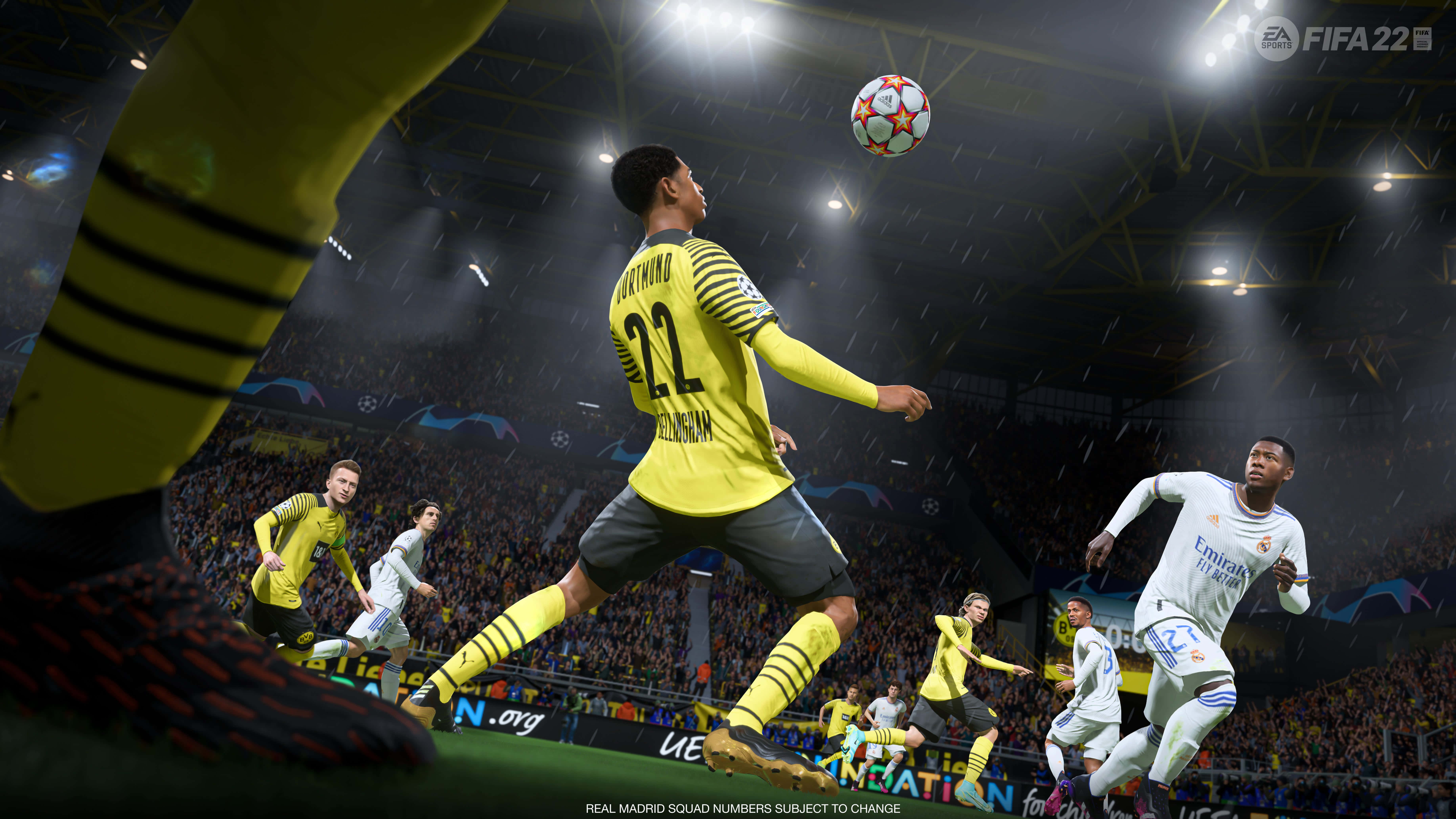 Fifa 22 桌布 壁紙 — 一名身穿黃色球衣的足球員在雨夜球場燈光下跳起頂球。