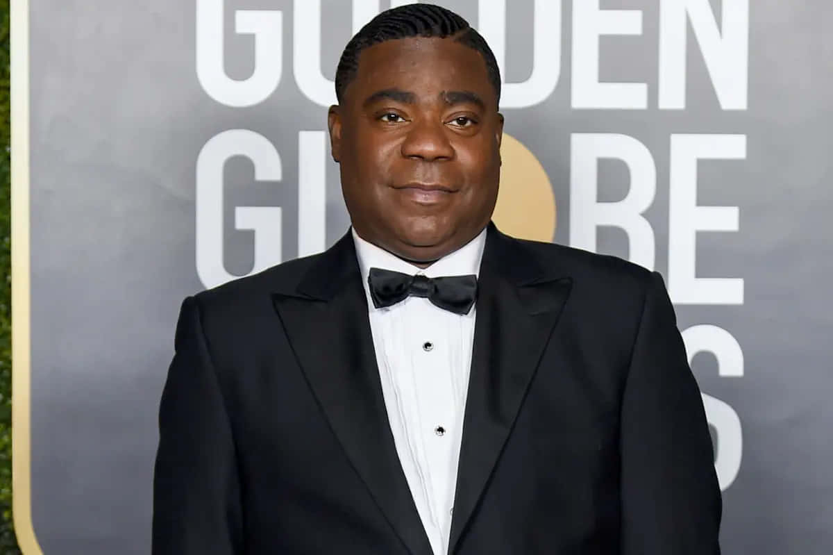 Tracy Morgan 桌布 壁紙 — 一名身穿黑色燕尾服配蝴蝶結的男子自信地站在金球獎紅地毯活動上。