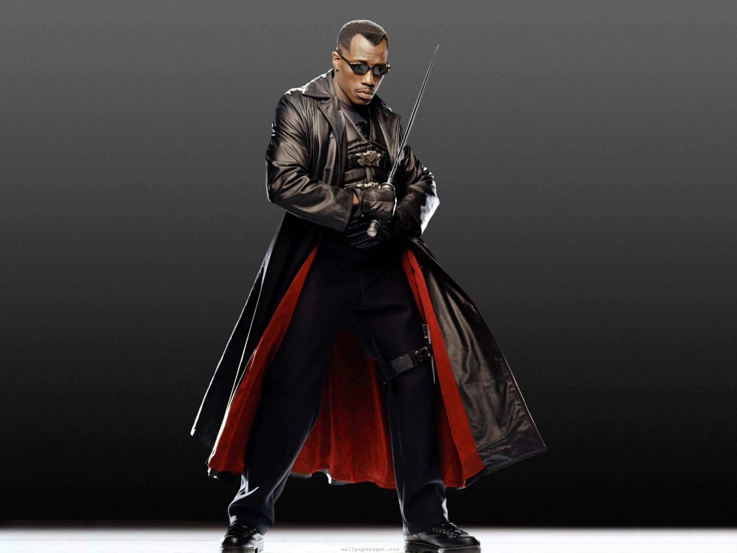 Wesley Snipes 桌布 壁紙 — 一名身穿黑色皮褸、紅色內裡的男人，在深色漸變背景前手持劍站立。
