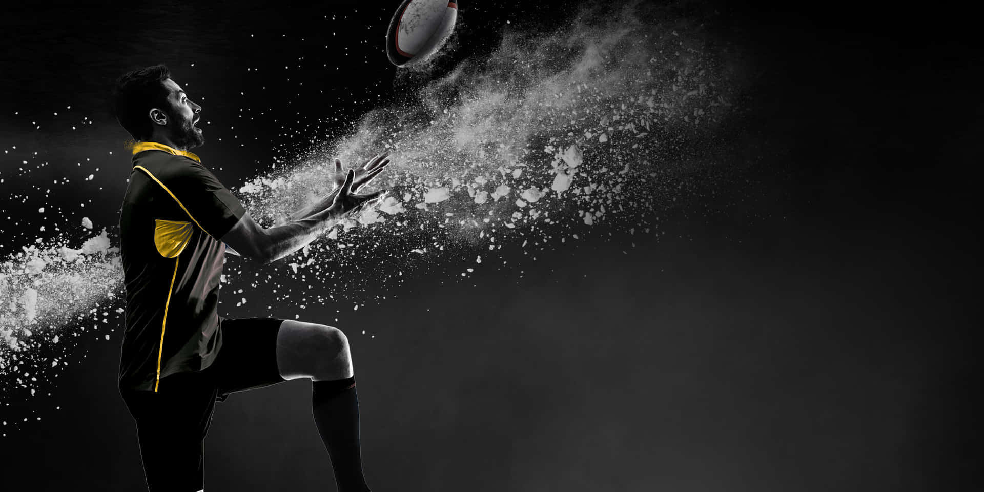 Best Sports 桌布 壁紙 — 一名身穿黑黃色球衣的欖球運動員踢球，白色粉末在黑暗背景中戲劇性地慢動作爆炸。