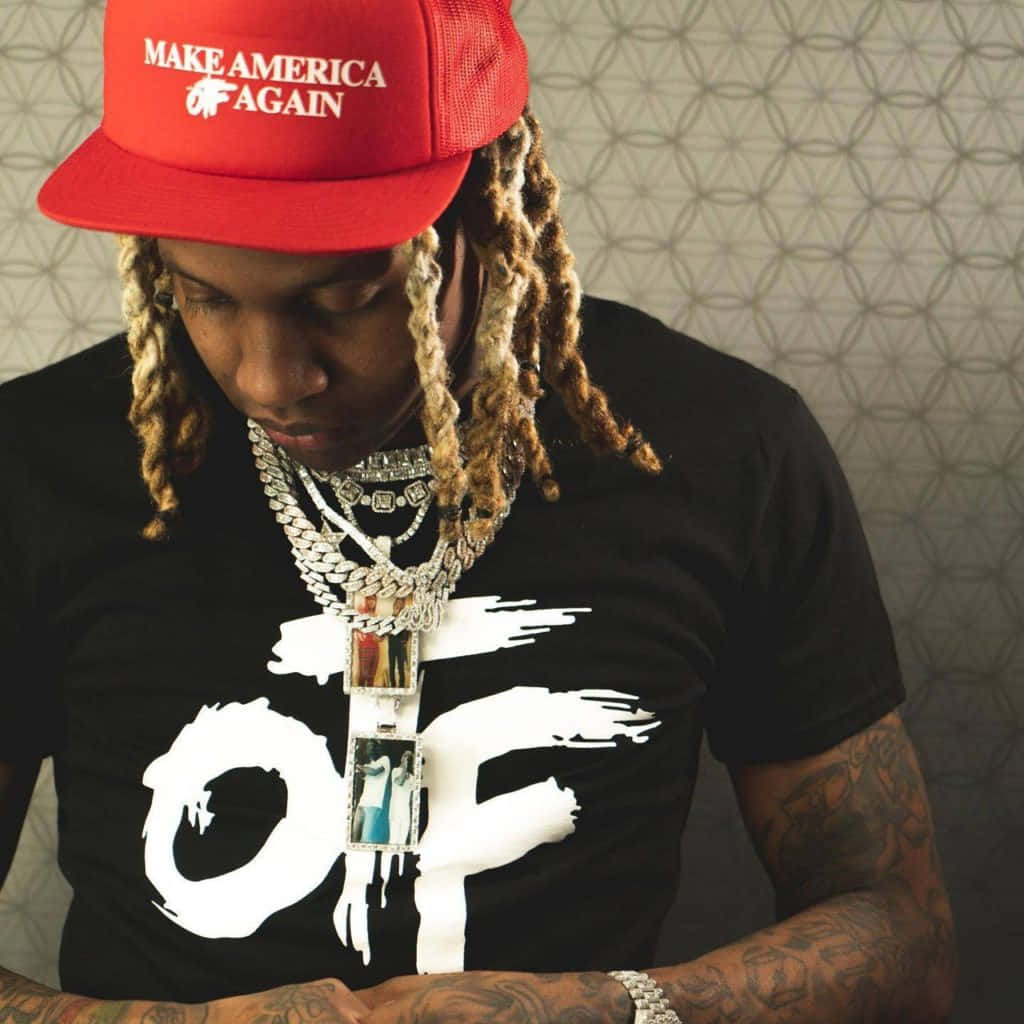lil durk 桌布 壁紙 — 一名辮子男戴著紅色「Make America Again」帽子和多層銀鏈，背景係有圖案嘅牆。