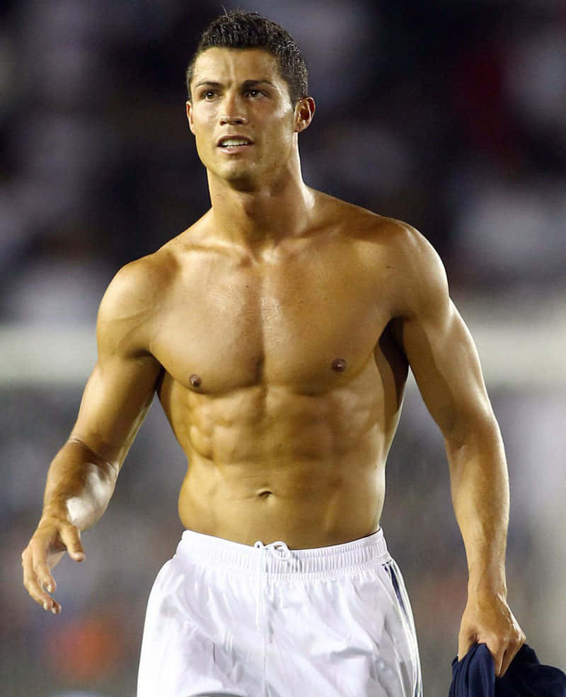 Ronaldo 桌布 壁紙 — 一名運動型赤裸上身的男子，肌肉線條分明，在明亮的燈光下於球場上行走。