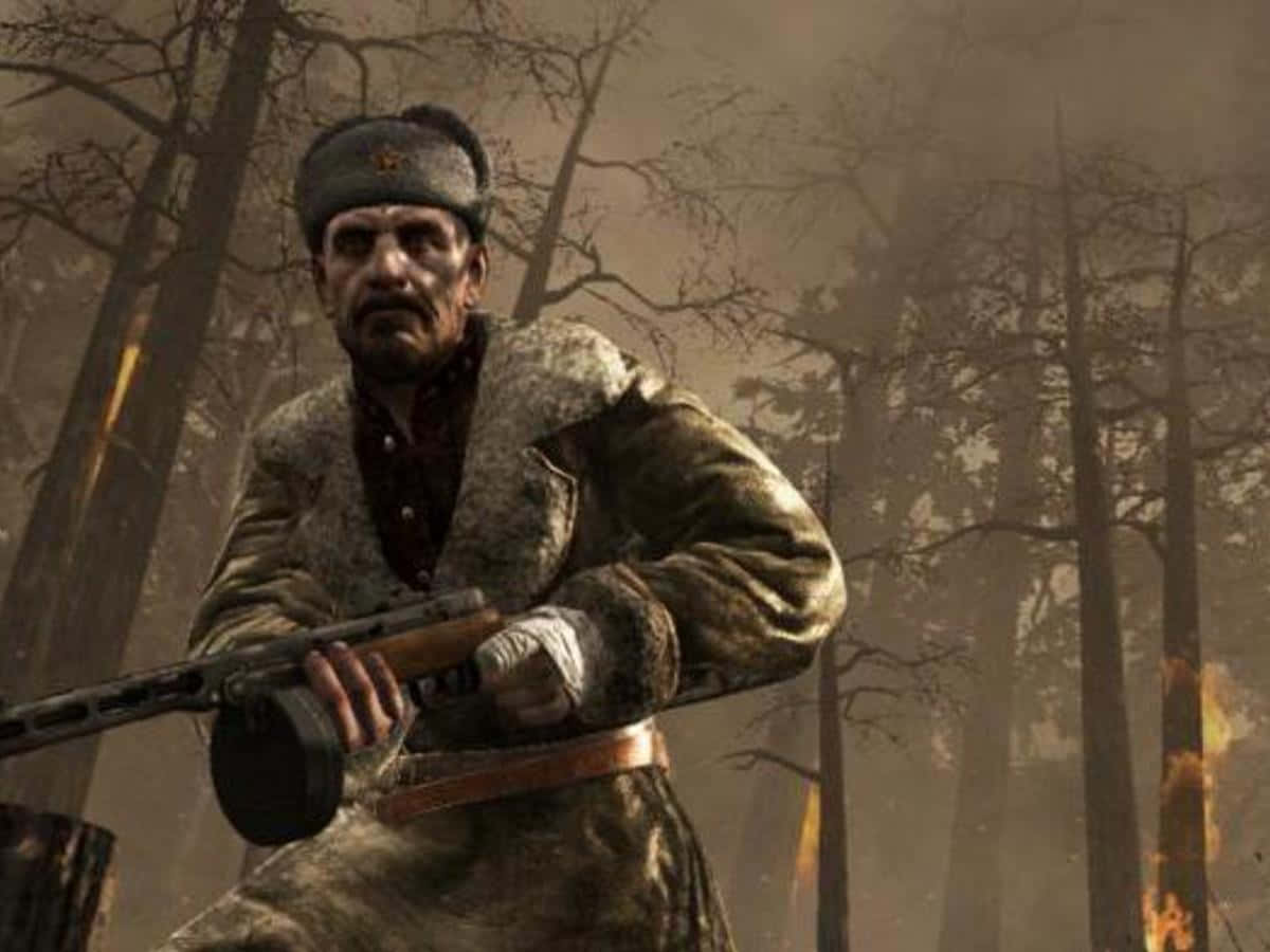 Viktor Reznov 桌布 壁紙 — 一名陰沉的士兵在森林中手持步槍，身後煙霧瀰漫，火焰舔舐著樹木。