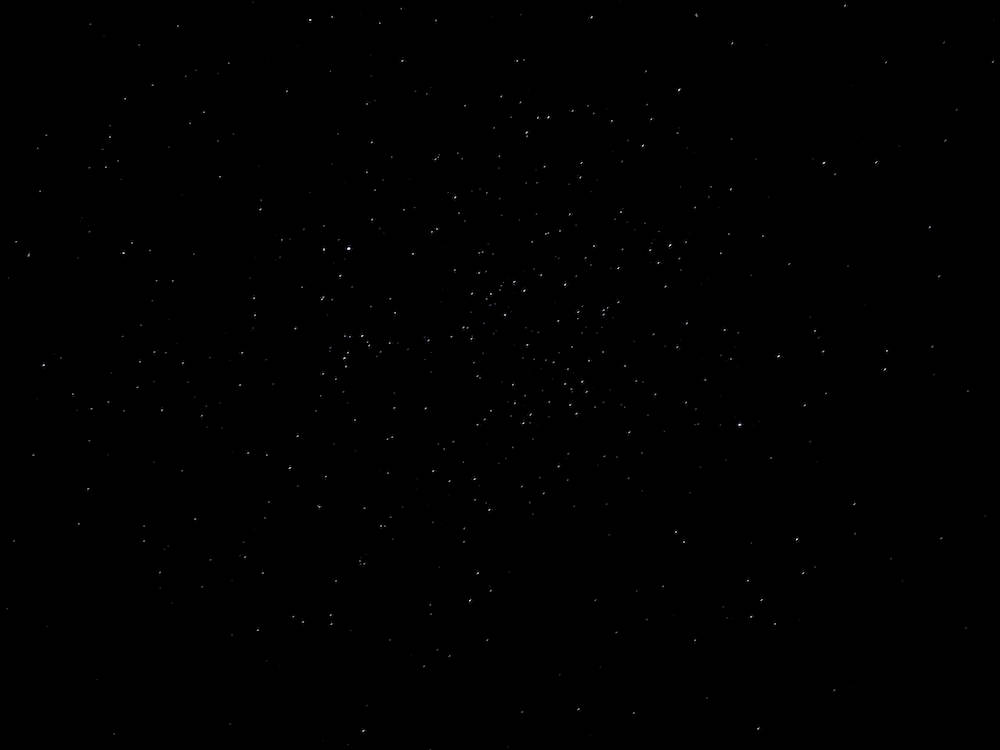黑色動態圖 桌布 壁紙 — 一團密集的明亮白色星星散落在深邃的黑色宇宙虛空中。