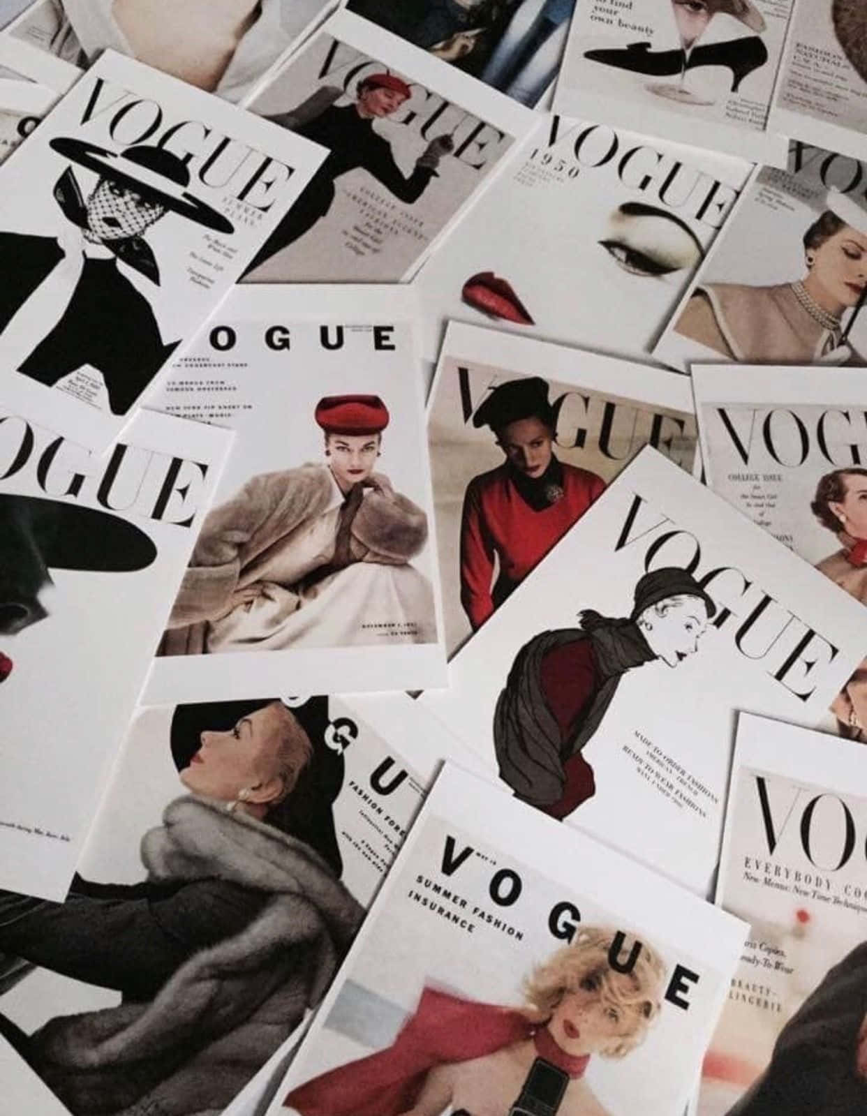 Magazine 桌布 壁紙 — 一堆散落的復古Vogue雜誌封面，展示經典時尚攝影中的迷人女性。