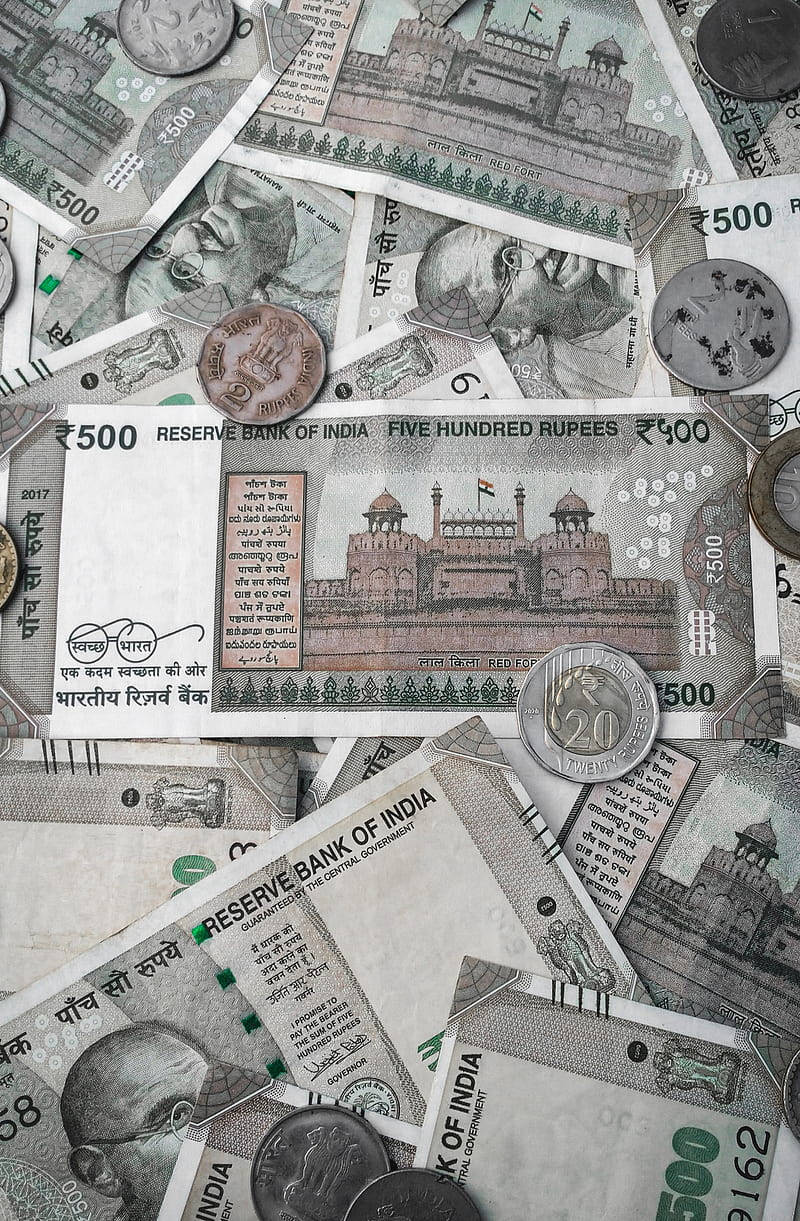 Indian 桌布 壁紙 — 一堆混亂的印度盧比紙幣和硬幣，上面有柔和大地色調的肖像和建築圖案。