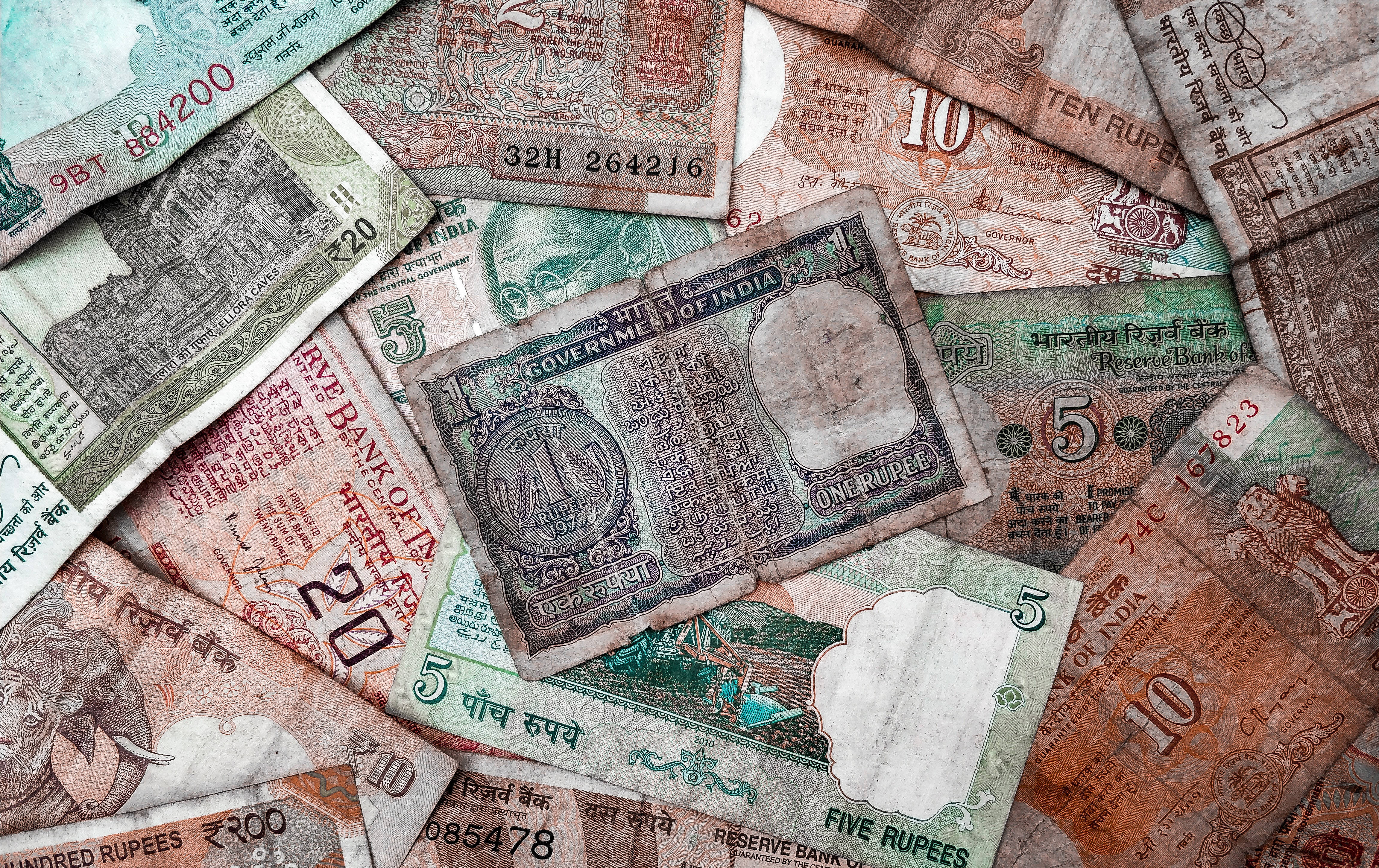 Indian 桌布 壁紙 — 一堆混亂的復古印度盧比紙幣，面額和顏色各異。