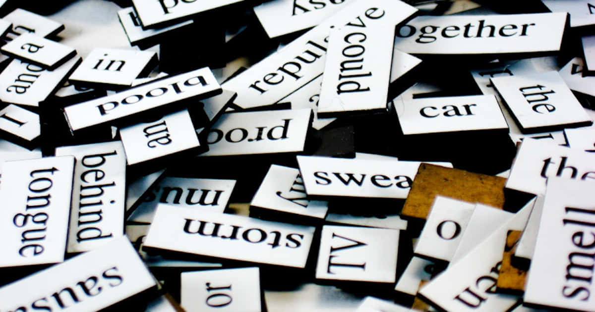 Word 桌布 壁紙 — 一堆白色字母瓷磚散落在深色表面上，上面有黑色文字，混亂不堪。
