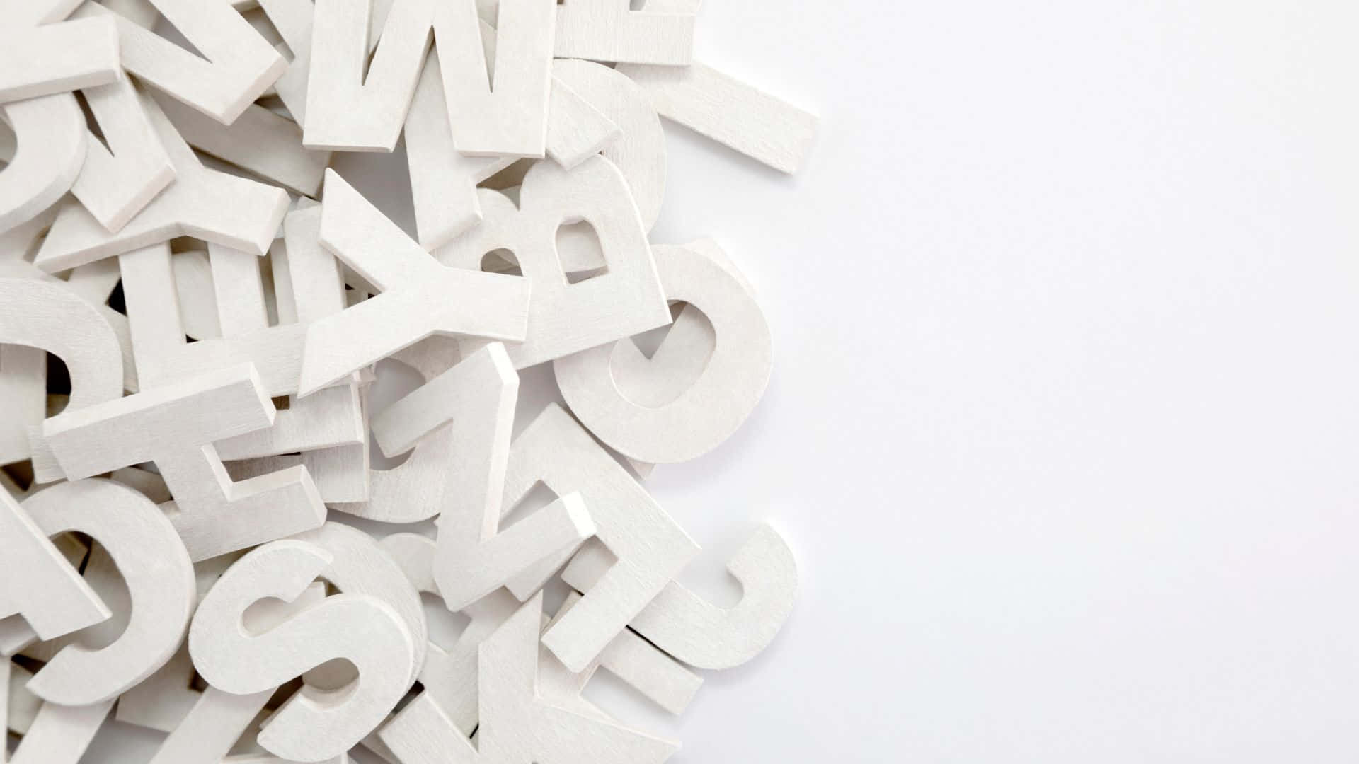 Typography 桌布 壁紙 — 一堆白色木製字母散落在乾淨的白色背景上，帶有柔和陰影。