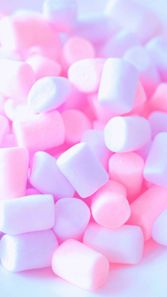 Marshmallow 桌布 壁紙 — 一堆粉紅色和白色的軟棉花糖在柔和光線下發光，景深較淺。