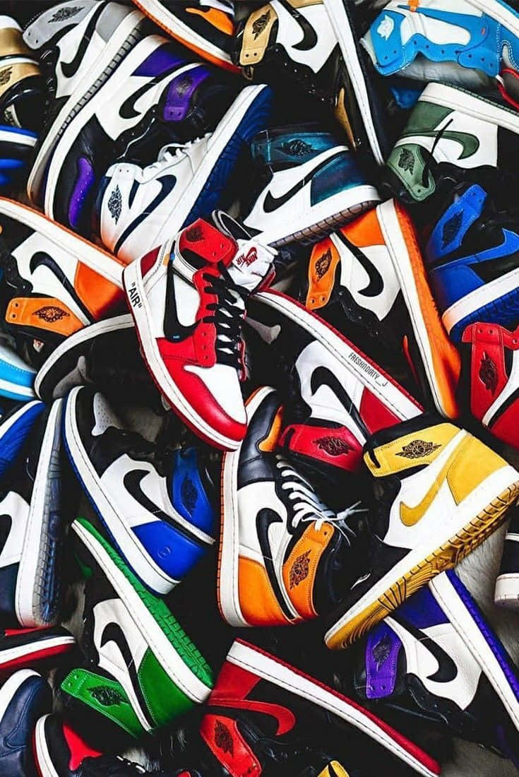 Sneaker 桌布 壁紙 — 一堆色彩繽紛、充滿活力的Nike Air Jordan波鞋，以各種大膽色調和經典設計雜亂地堆疊在一起。