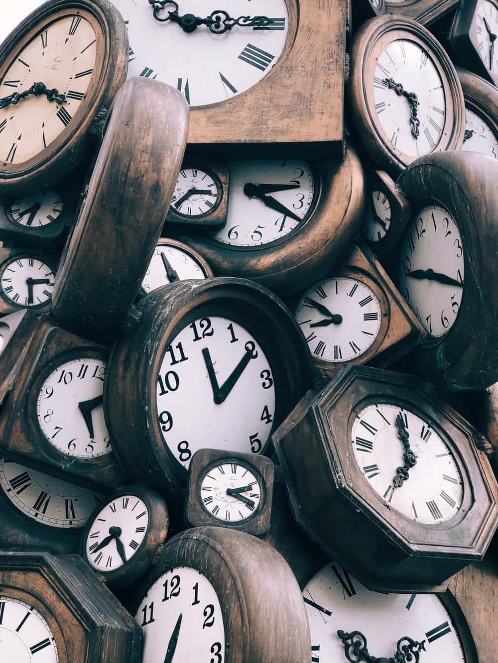 Time 桌布 壁紙 — 一堆雜亂的復古木鐘，帶有各種不同的錶面和指針，顯示不同的時間。