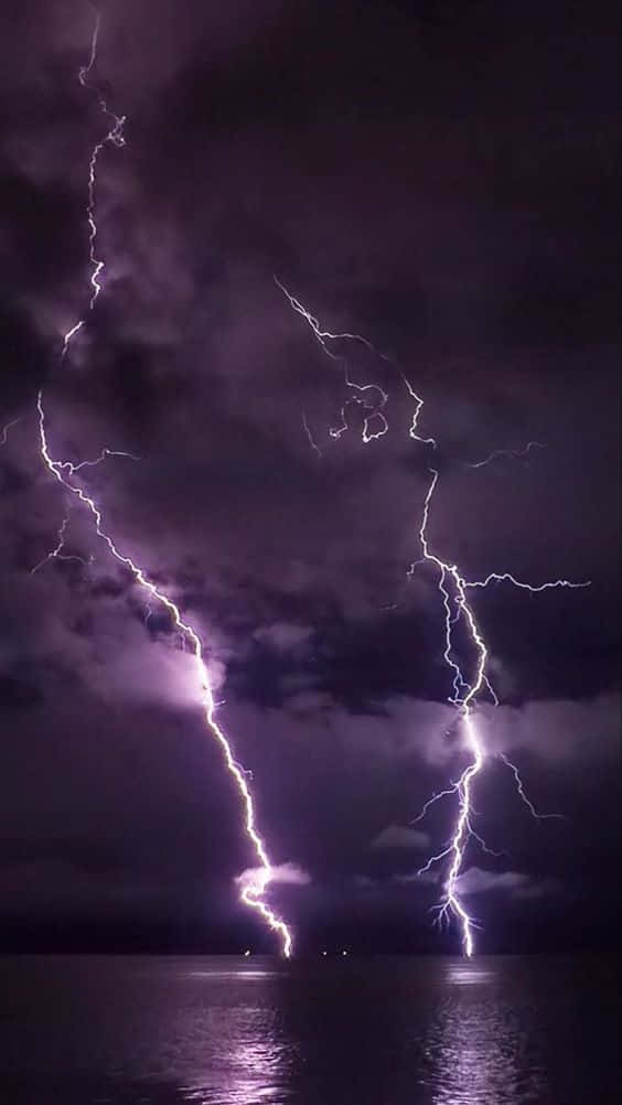 兩道強勁的閃電照亮了水面上黑暗的暴風雨之夜。