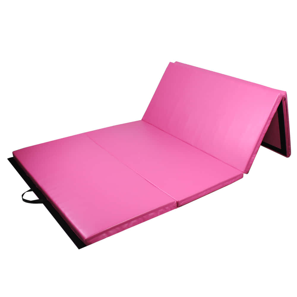 Gymnastics Mat 桌布 壁紙 — 一塊亮粉紅色可摺疊體操墊，帶黑色邊框和手提把手，置於白色背景上。