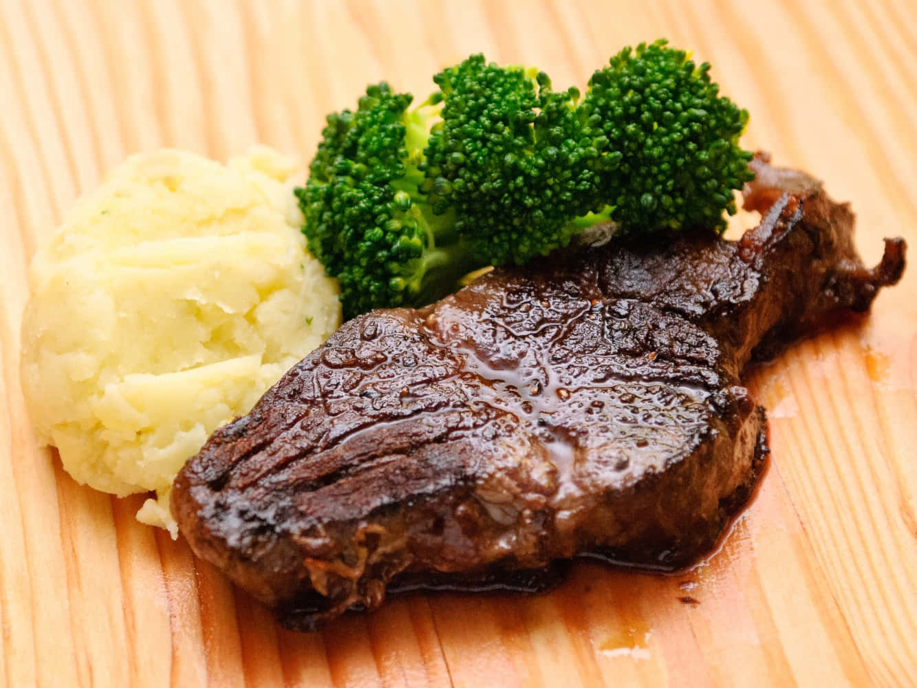 meat 桌布 壁紙 — 一塊多汁的煎牛排配上薯蓉和鮮綠的西蘭花，放在溫暖的木板上。