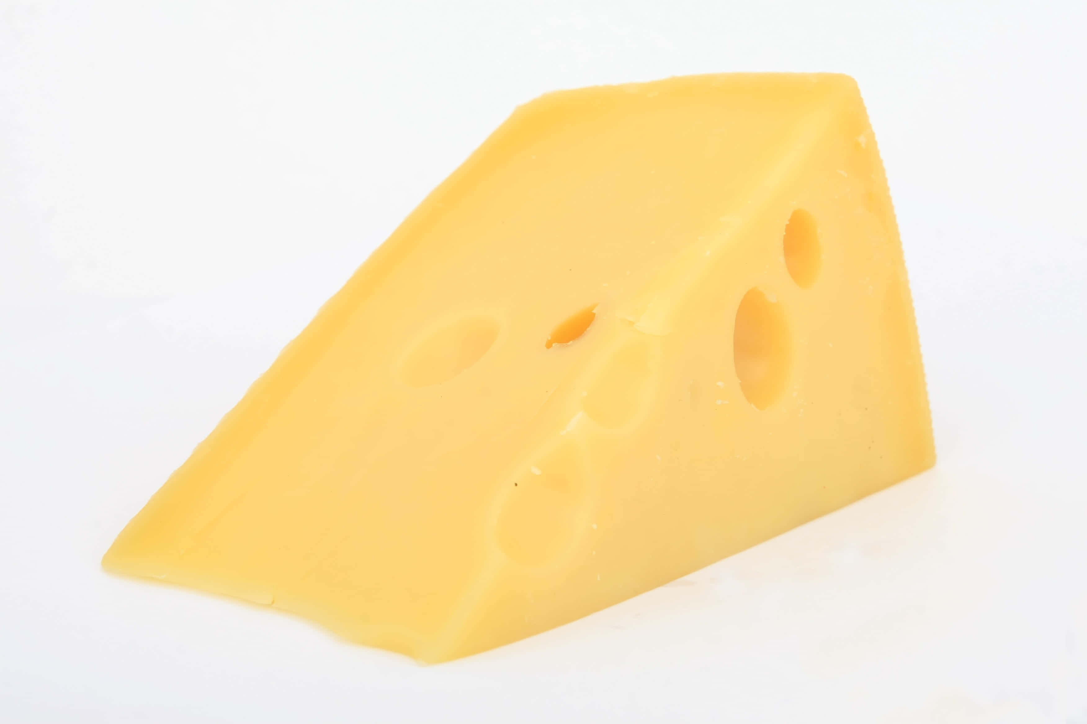 Cheese 桌布 壁紙 — 一塊帶有特徵孔洞的黃色瑞士芝士放在純白表面上。