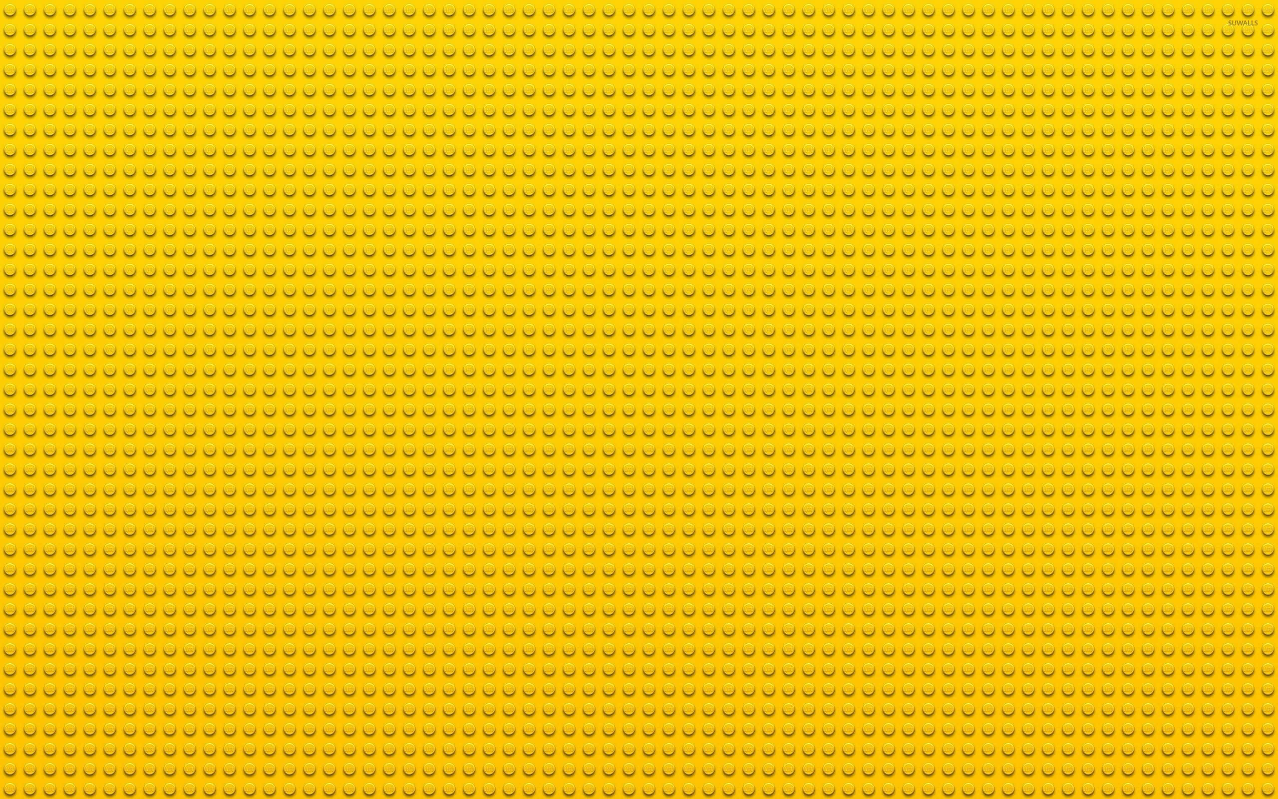 Yellow Abstract 桌布 壁紙 — 一塊無縫的黃色樂高底板，重複的圓形凸點覆蓋整個框架。