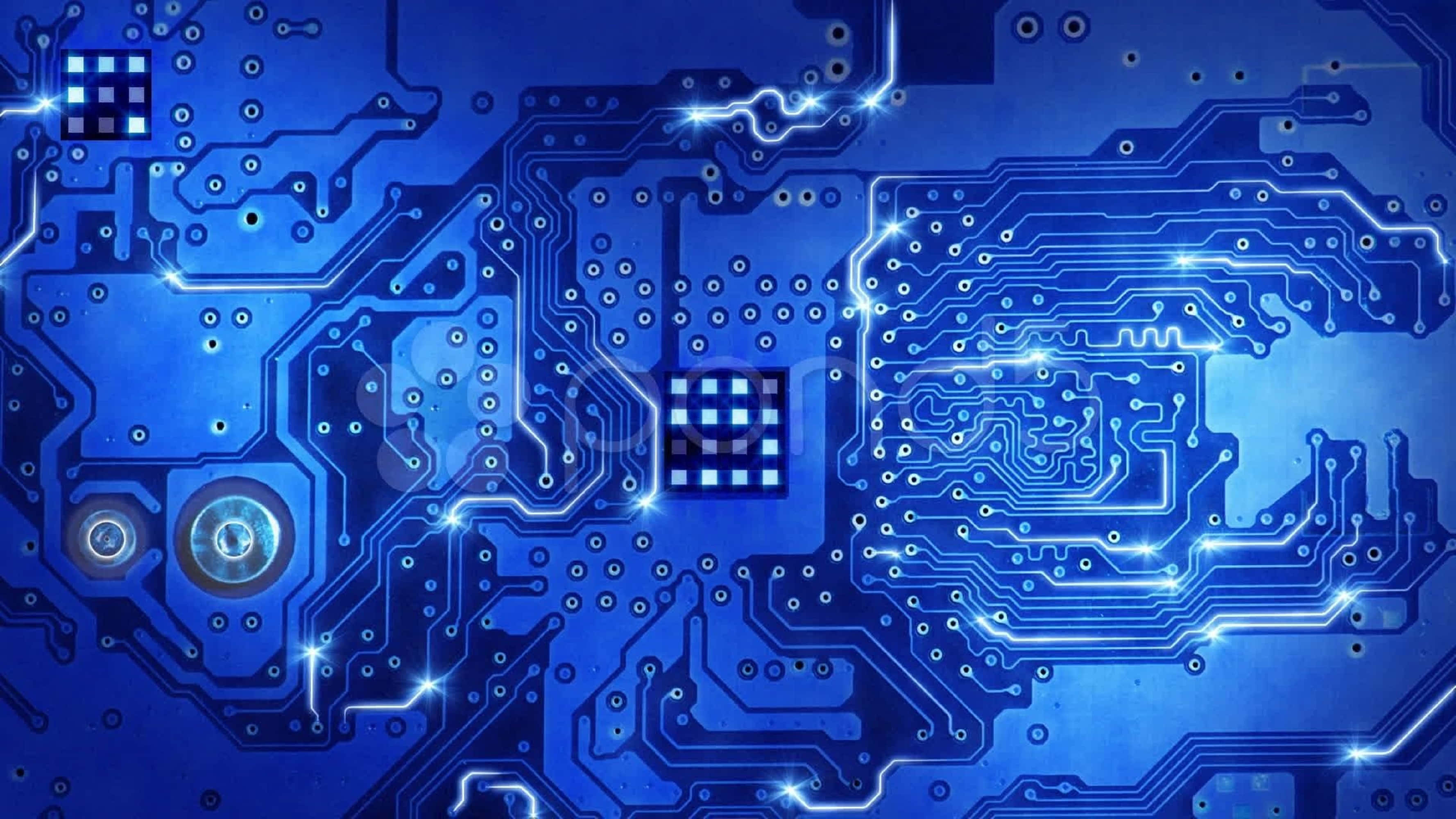 4K Processor 桌布 壁紙 — 一塊發光藍色電路板，帶有複雜的路徑和明亮的燈光效果，背景為深色。