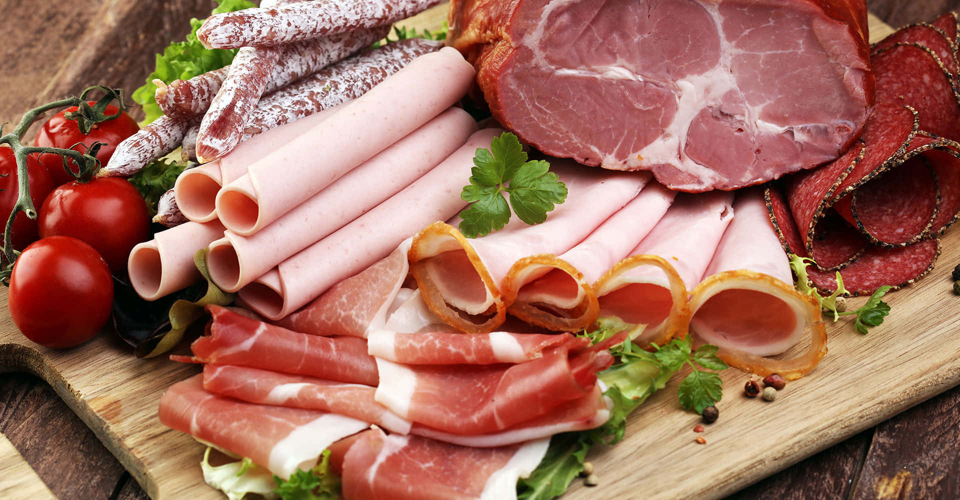 meat 桌布 壁紙 — 一塊質樸的木板上展示著令人垂涎的各式醃肉和新鮮車厘茄，並以歐芹點綴。